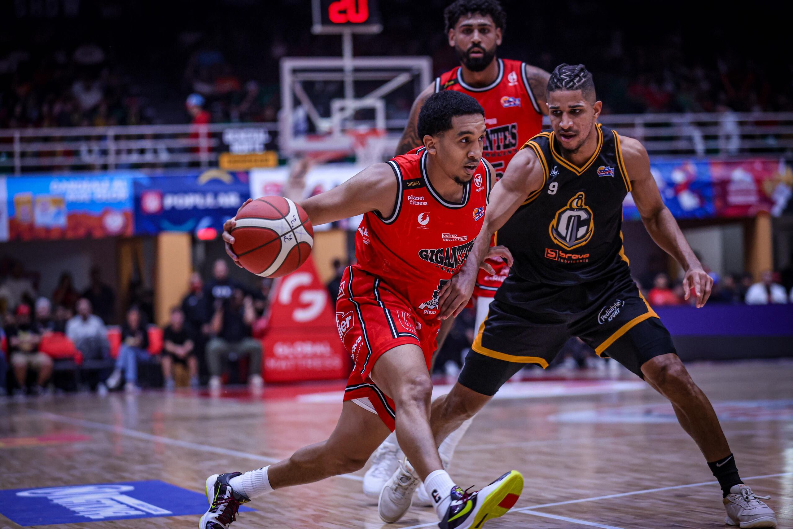 Tremont Waters, de los Gigantes de Carolina, controla el balón ante la defensa de Alfonso Plummer, de los Capitanes de Arecibo.