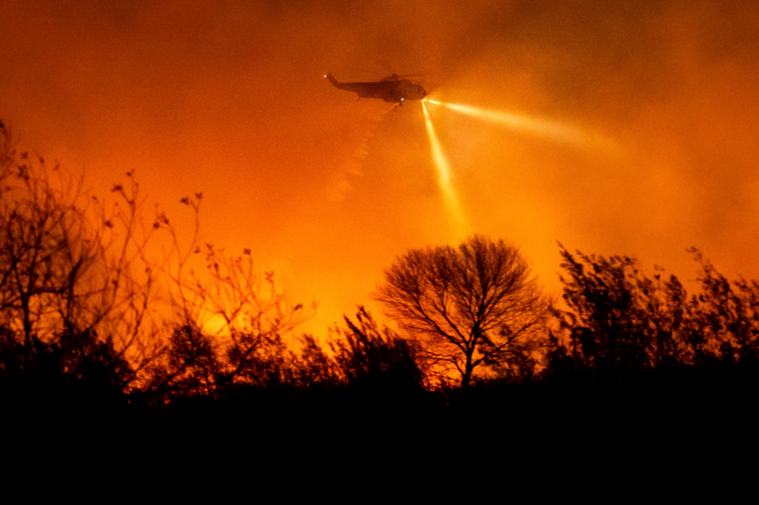 Un helicóptero lanza agua mientras combate el incendio Auto en el condado de Ventura, California, el 13 de enero de 2025.