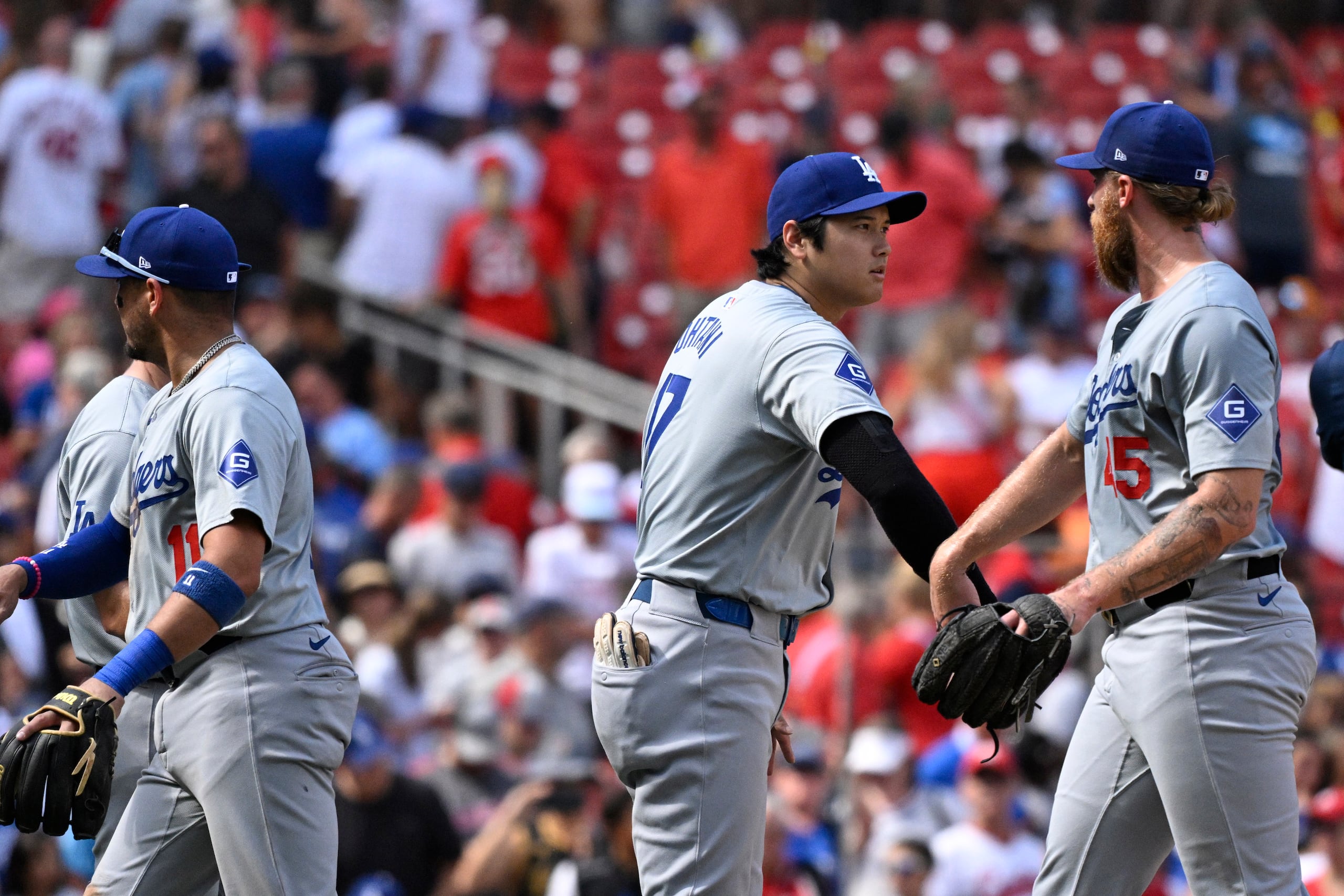 El bateador designado de los Dodgers de Los Ángeles, Shohei Ohtani (centro) felicita al relevista Michael Kopech (derecha) luego de vencer a los Cardinals.