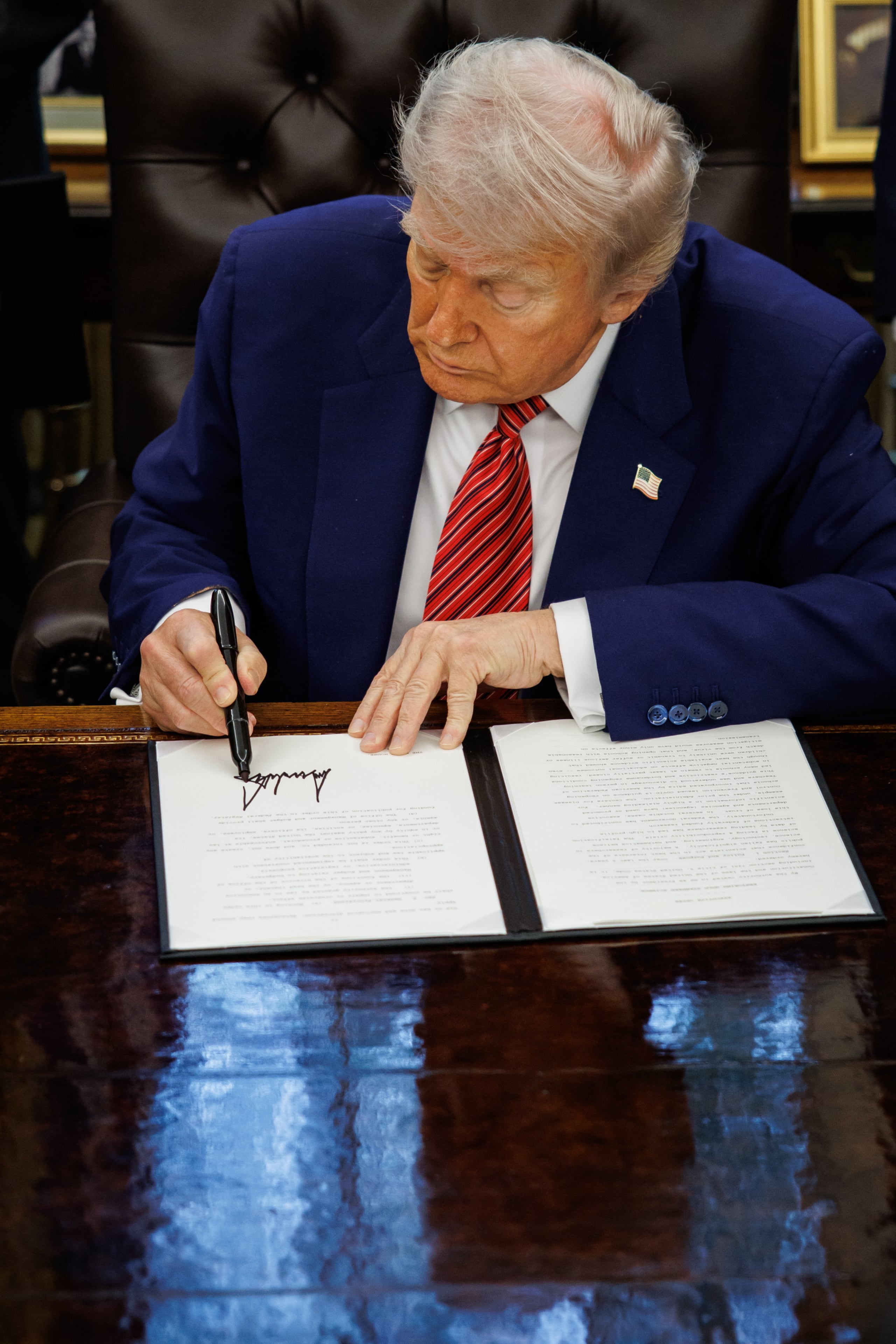 El presidente Donald Trump firmando las órdenes ejecutivas. (EFE/EPA/SAMUEL CORUM / POOL)