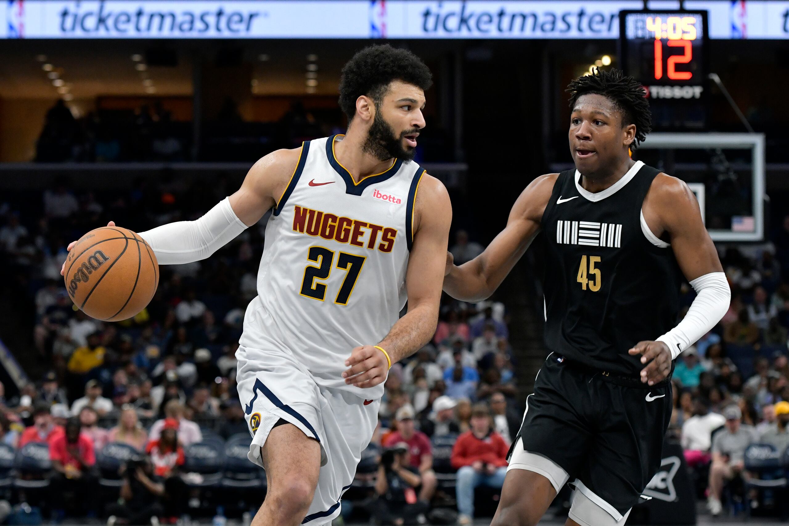 El armador de los Nuggets de Denver Jamal Murray (27) conduce el balón ante el alero de los Grizzlies de Memphis GG Jackson (45) en la segunda mitad del juego de baloncesto de la NBA, el domingo 14 de abril de 2024, en Memphis, Tennessee. (AP Foto/Brandon Dill)