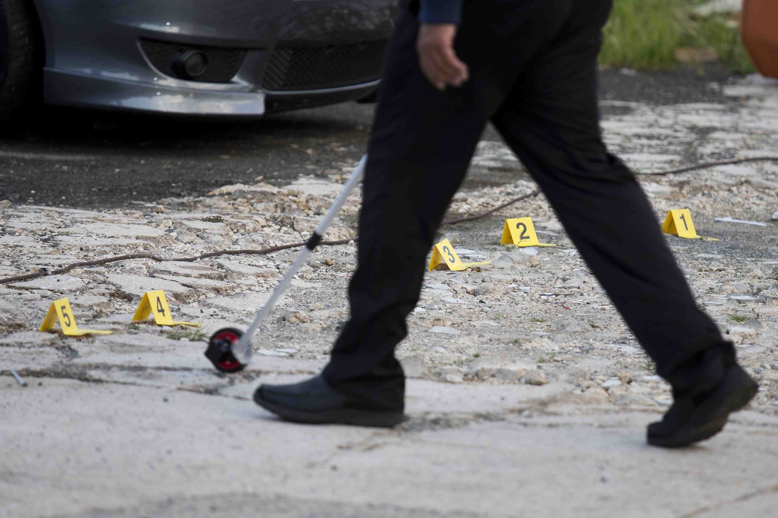 Un agente de la Policía toma medidas en la escena de un asesinato. (GFR Media)