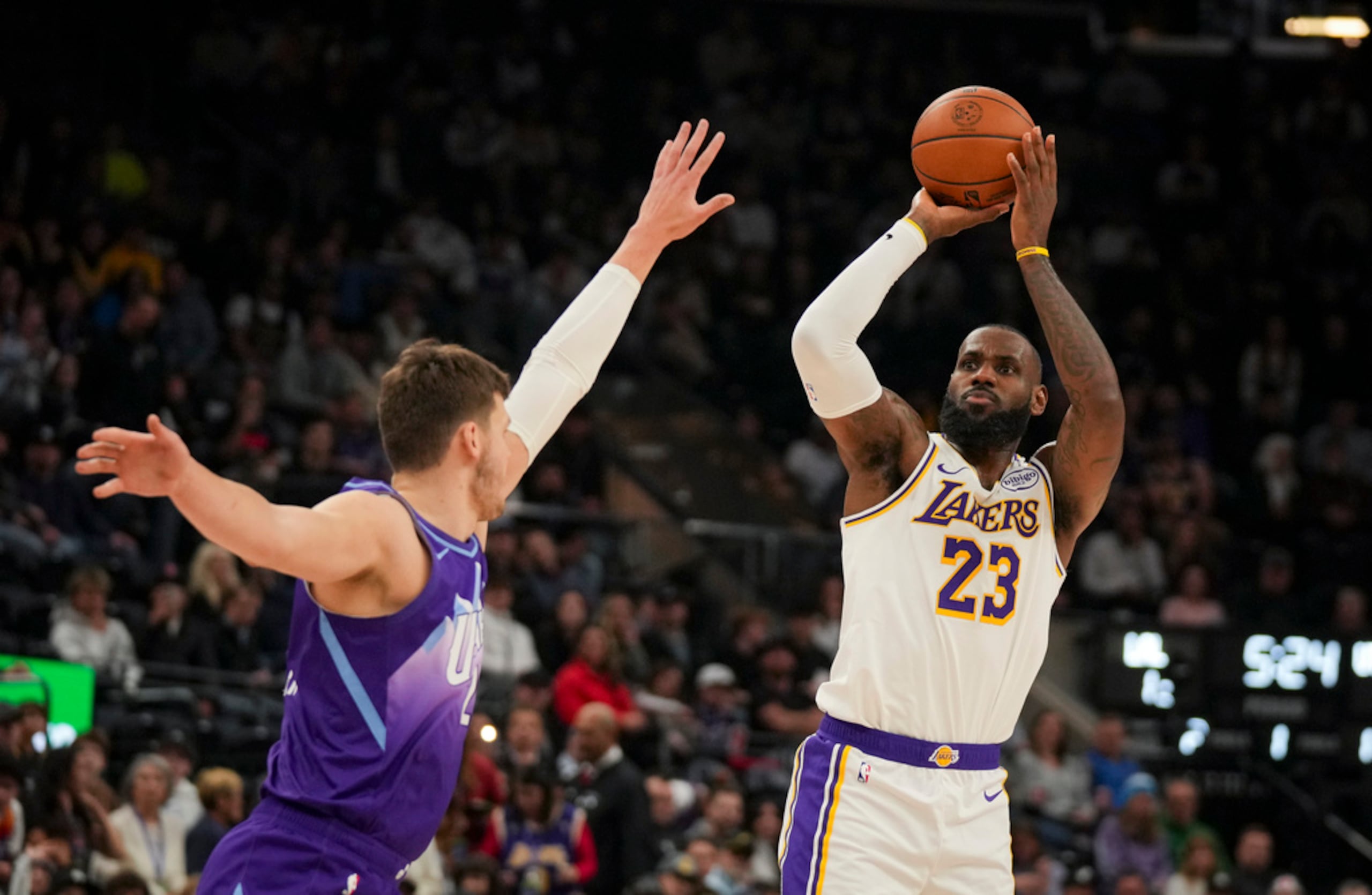 LeBron James, de los Lakers de Los Ángeles, dispara ante la presión defensiva de Walker Kessler, del Jazz de Utah, durante la primera mitad del juego de baloncesto de la NBA, el 1 de diciembre de 2024, en Salt Lake City.