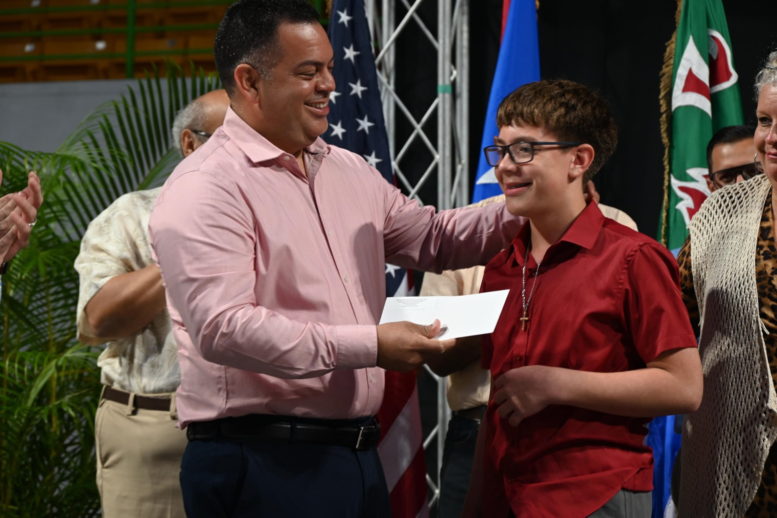 El alcalde de Mayagüez, Jorge L. Ramos, entrega una beca a uno de los estudiantes de su municipio.