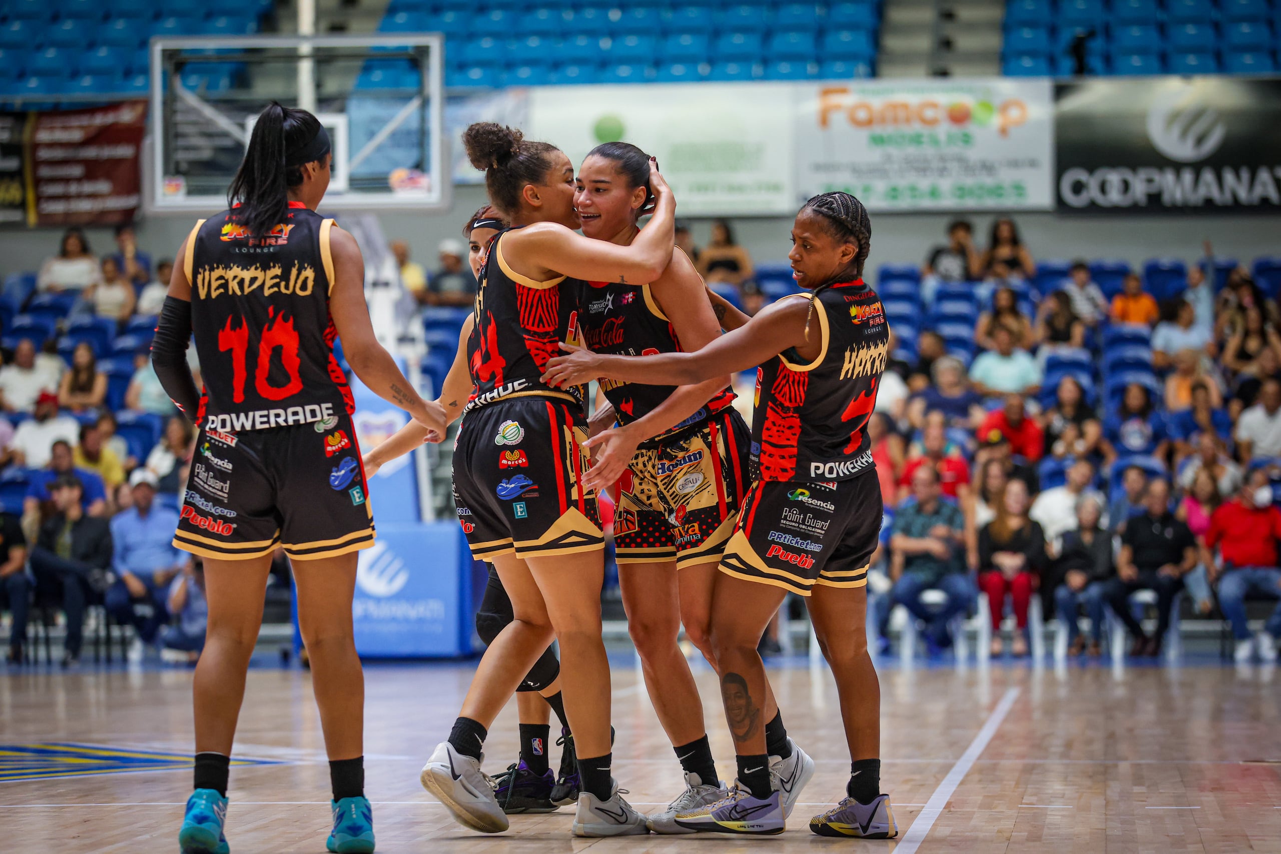 Las jugadoras de las Gigantes de Carolina abrazan a Tayra Meléndez, después de anotar un triple en el quinto juego de la serie final del BSNF.