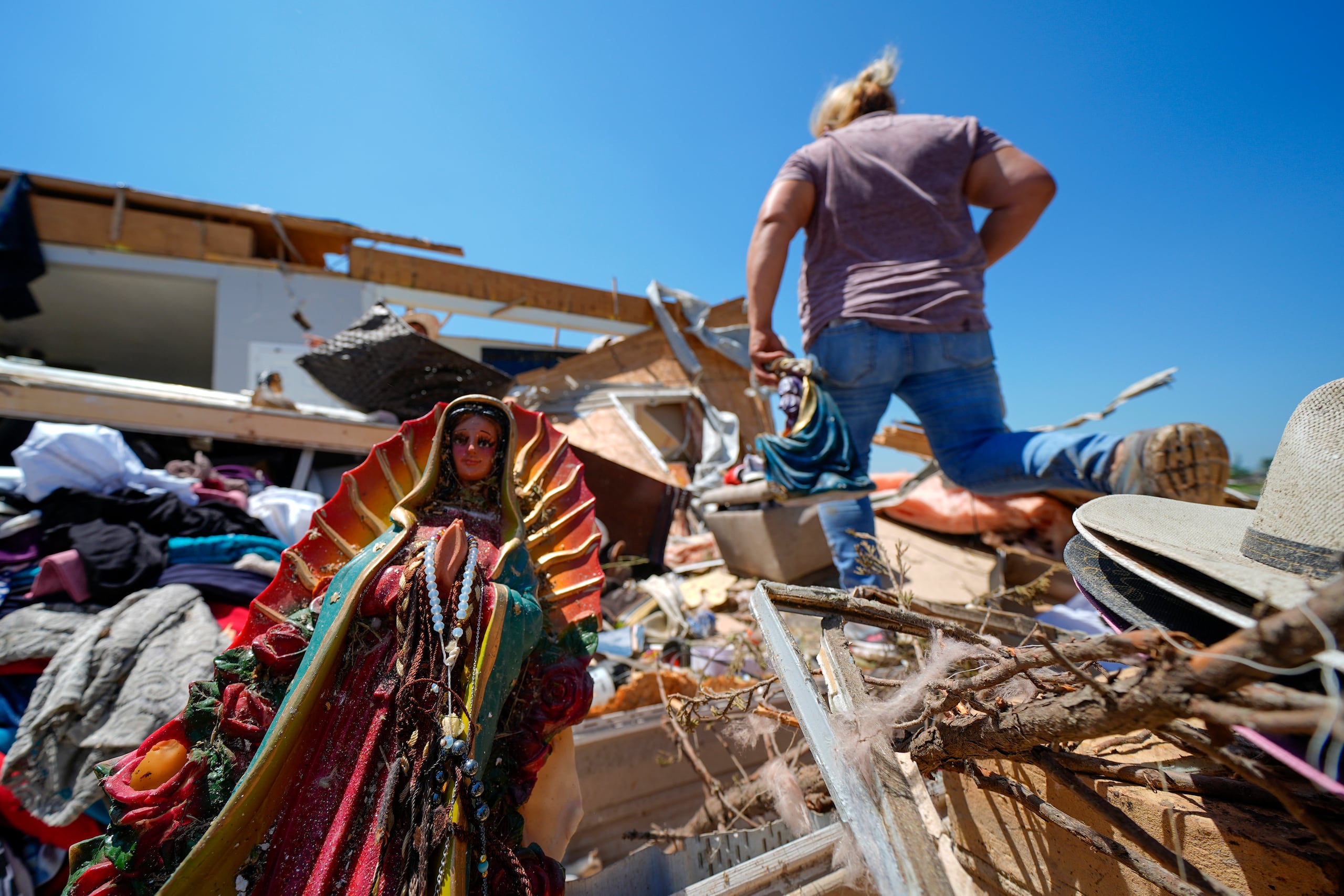 Una figura de la Virgen de Guadalupe sobresale de los escombros de la casa de Juana Landeros, quien permaneció en su residencia junto con su esposo y su hijo de nueve años durante un tornado la noche previa, el domingo 26 de mayo de 2024, en Valley View, Texas. (AP Foto/Julio Cortez)