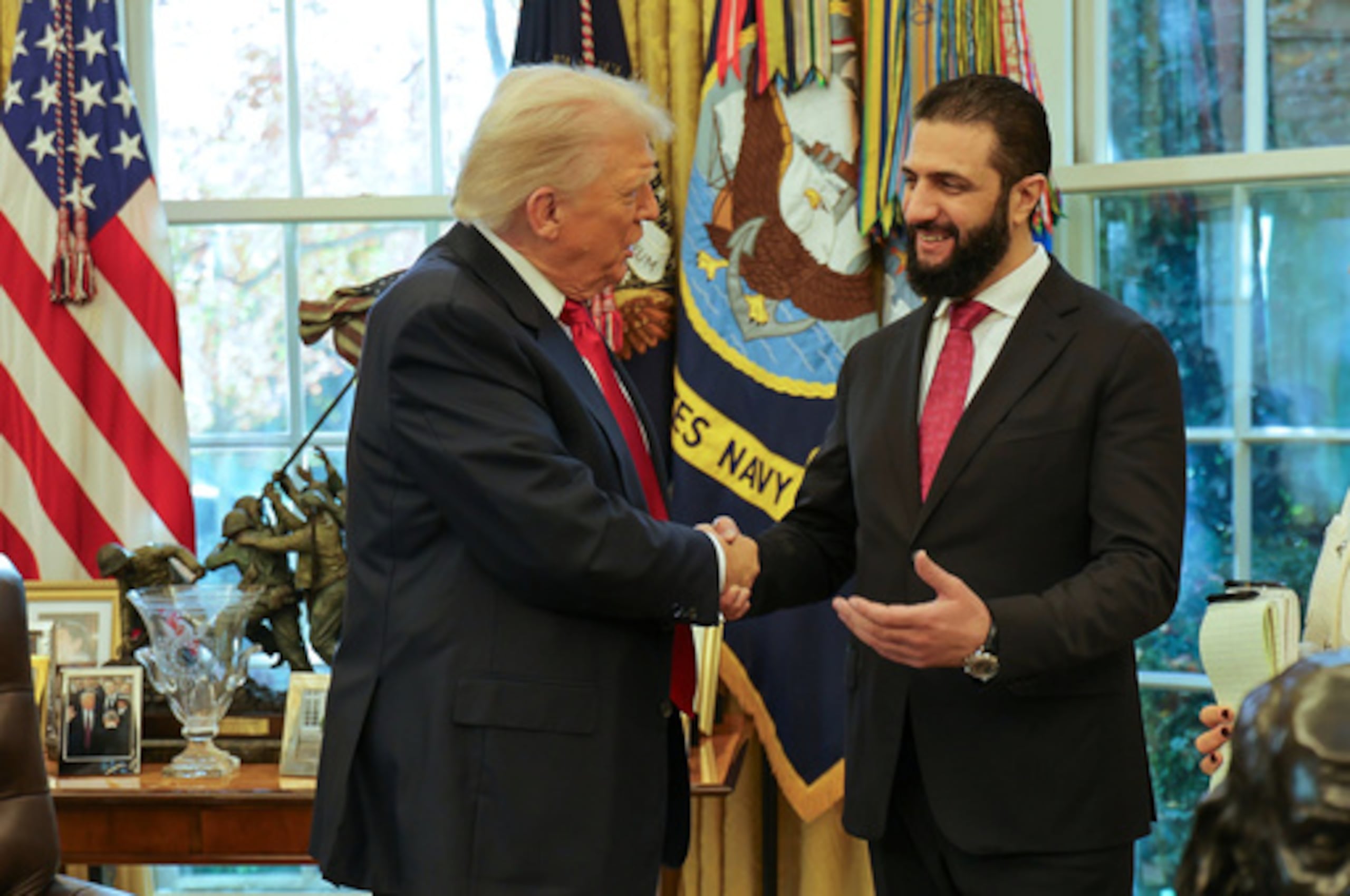 ARCHIVO - En esta fotografía difundida por la oficina de prensa de la Presidencia siria, el presidente Donald Trump, a la izquierda, estrecha la mano del presidente sirio Ahmad al-Sharaa en la Casa Blanca, en Washington, el lunes 10 de noviembre de 2025. (Oficina de prensa de la Presidencia siria vía AP, archivo)