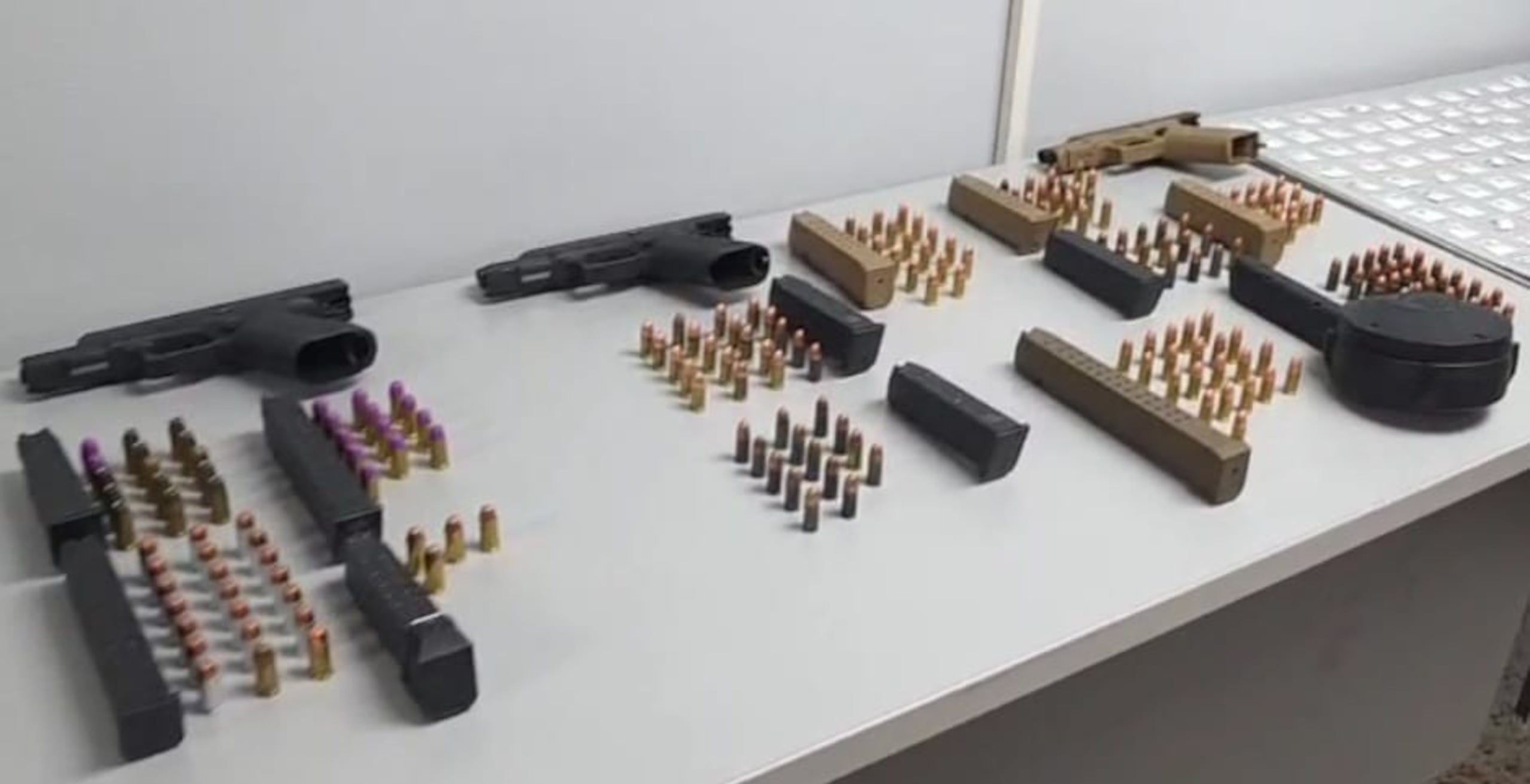 Armas de fuego, cargadores y balas ocupadas por agentes de la División de Drogas Metropolitana durante allanamientos en el residencial San Juan Bautista, en Santurce.
