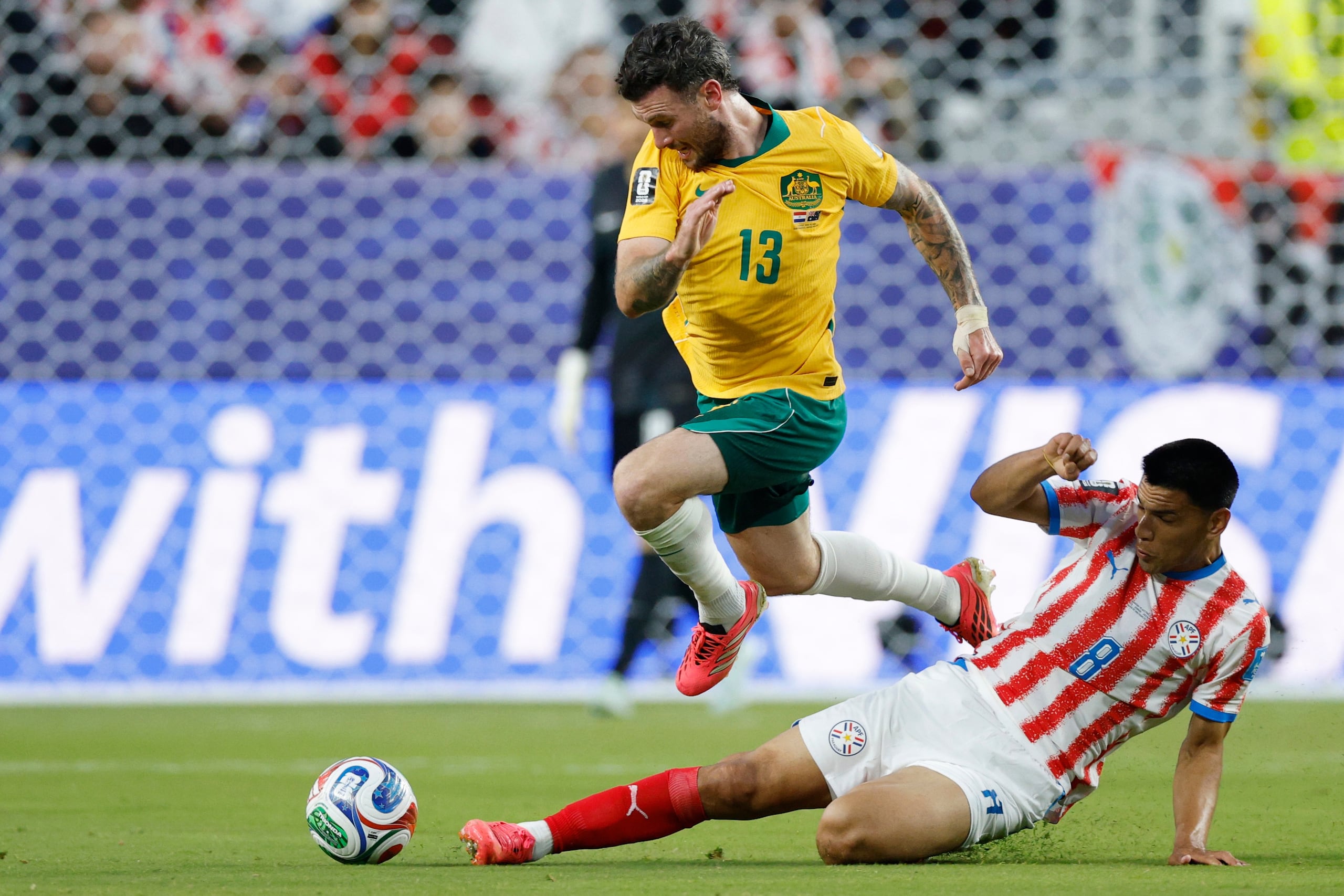El mediocampista Aiden O'Neill supera una barrida del paraguayo Diego Gómez.
