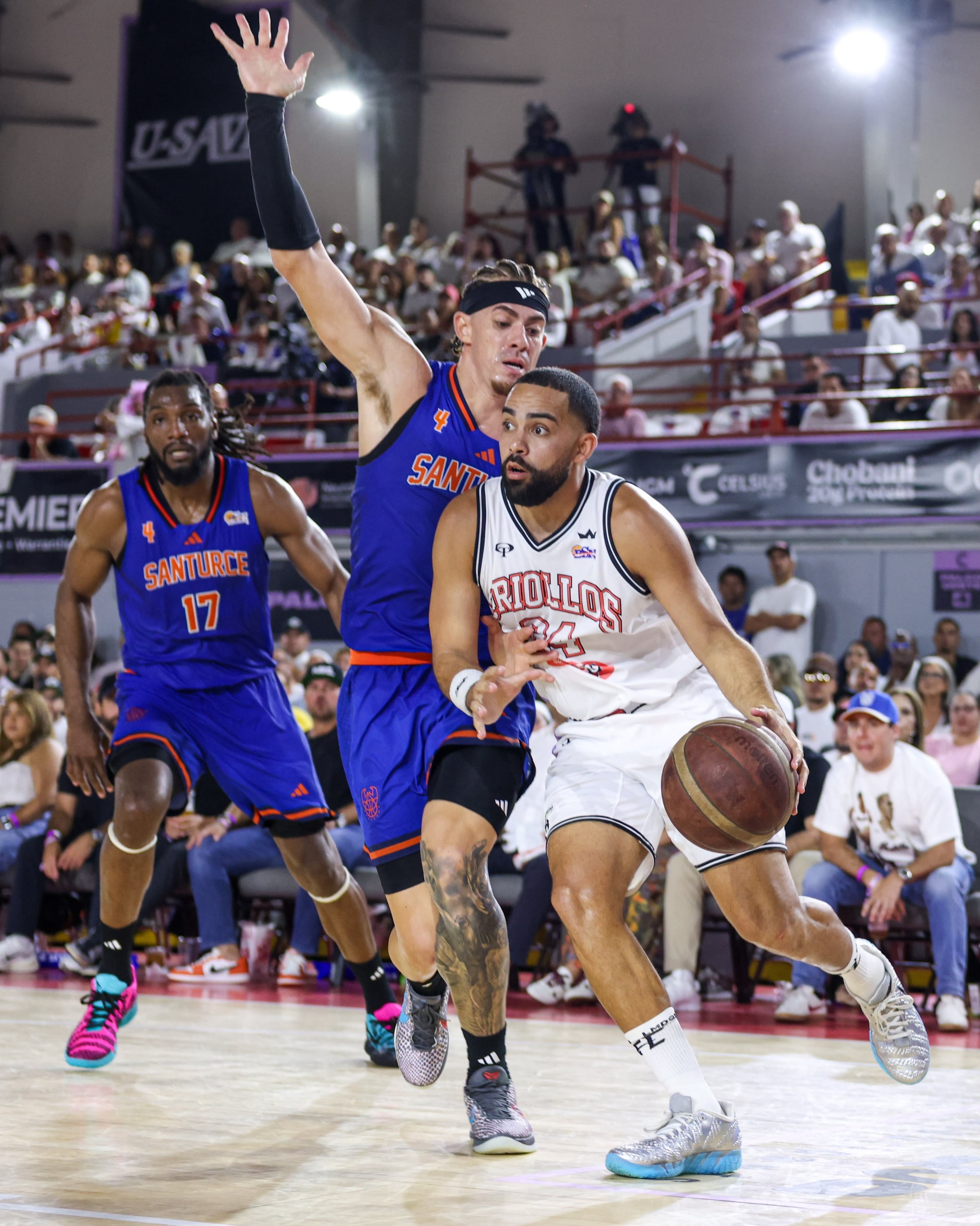 Christian "Cuco" López maneja el balón ante la presión de Isaiah Piñeiro en el primer juego de la semifinal de la Conferencia A del BSN entre Caguas y Santurce.