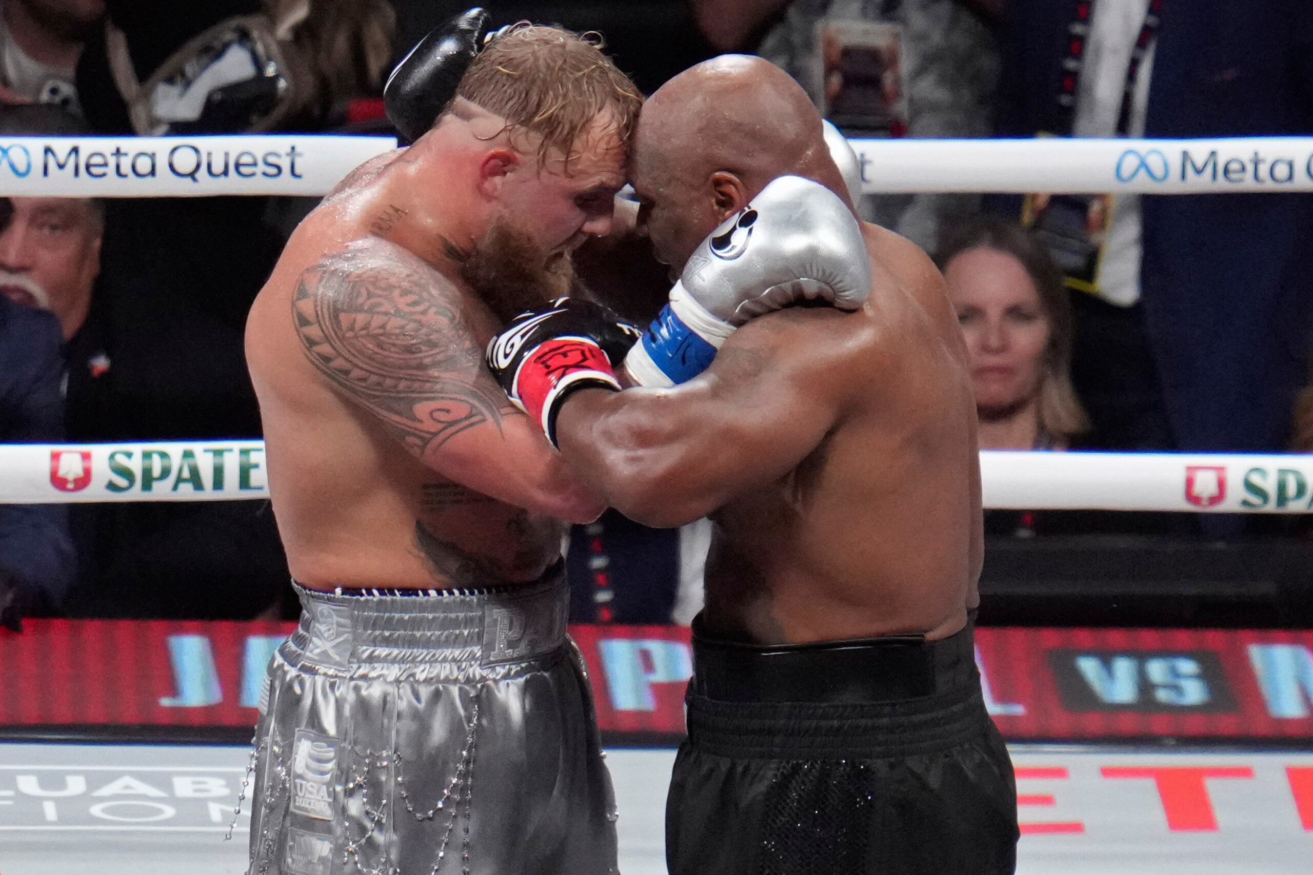 Jake Paul y Mike Tyson se abrazan después de su combate de boxeo en la división de peso pesado, el viernes 15 de noviembre de 2024, en Arlington, Texas. (Foto AP/Julio Cortez)
