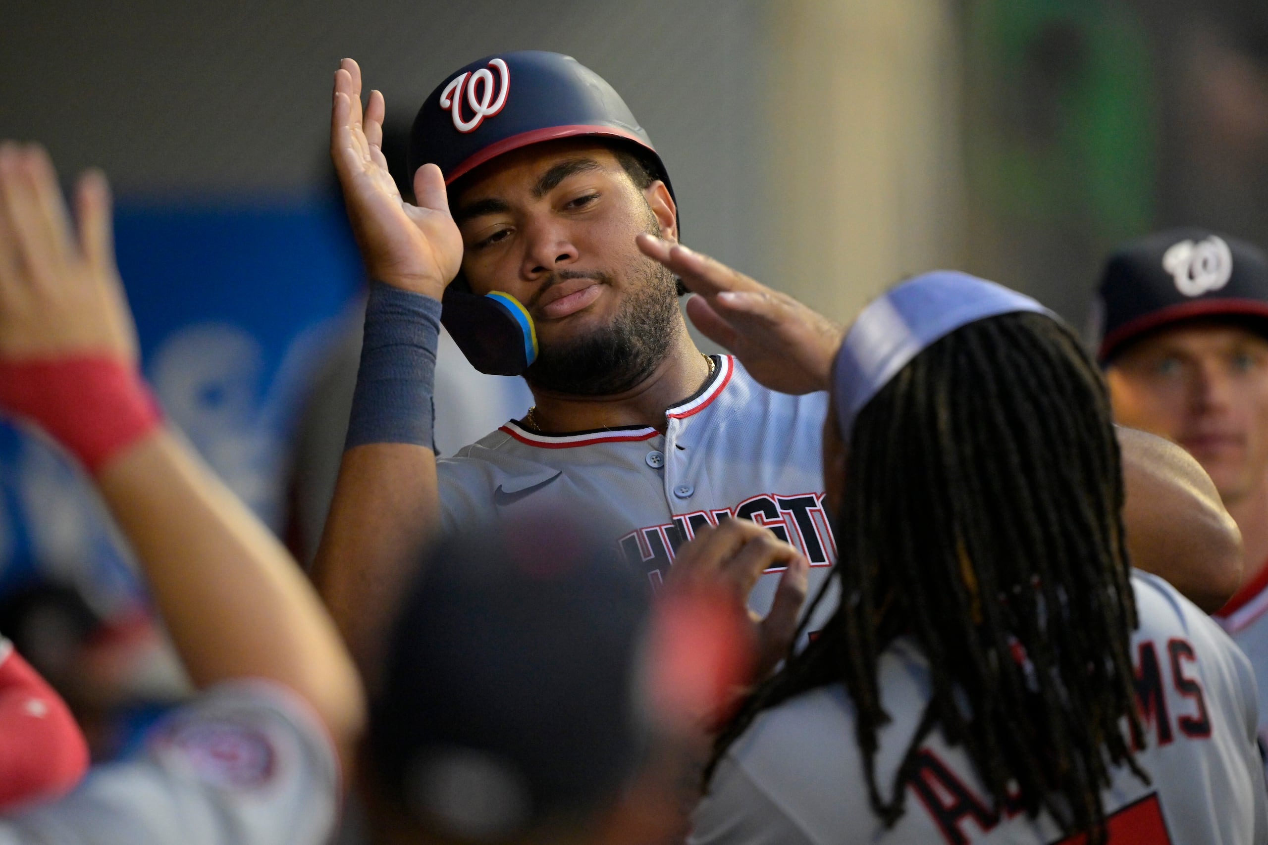 James Wood, de los Nationales de Washington, es felicitado en el dugout después de anotar en un doble de Nathaniel Lowe durante la quinta entrada del juego de béisbol de Grandes Ligas.