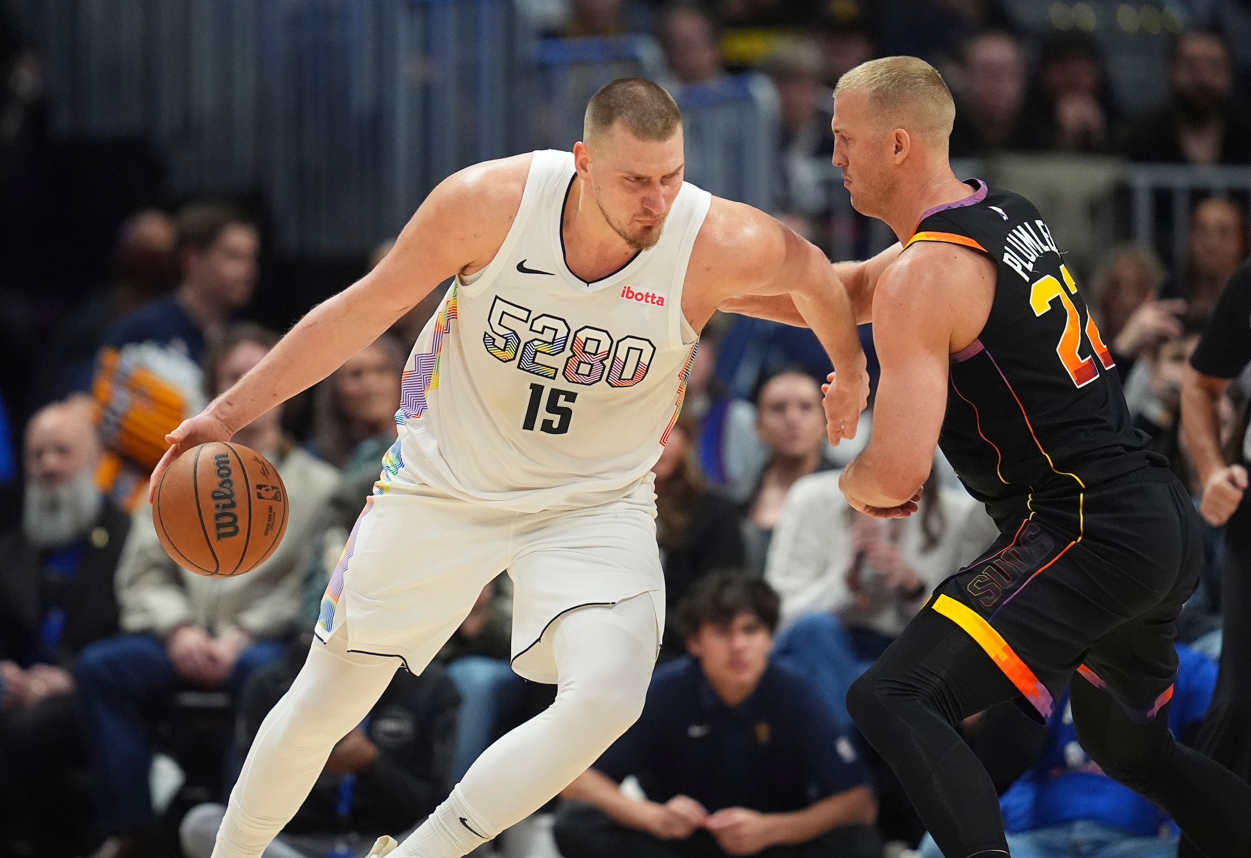 Nikola Jokic, a la izquierda, maneja el balón ante la defensa de Mason Plumlee.