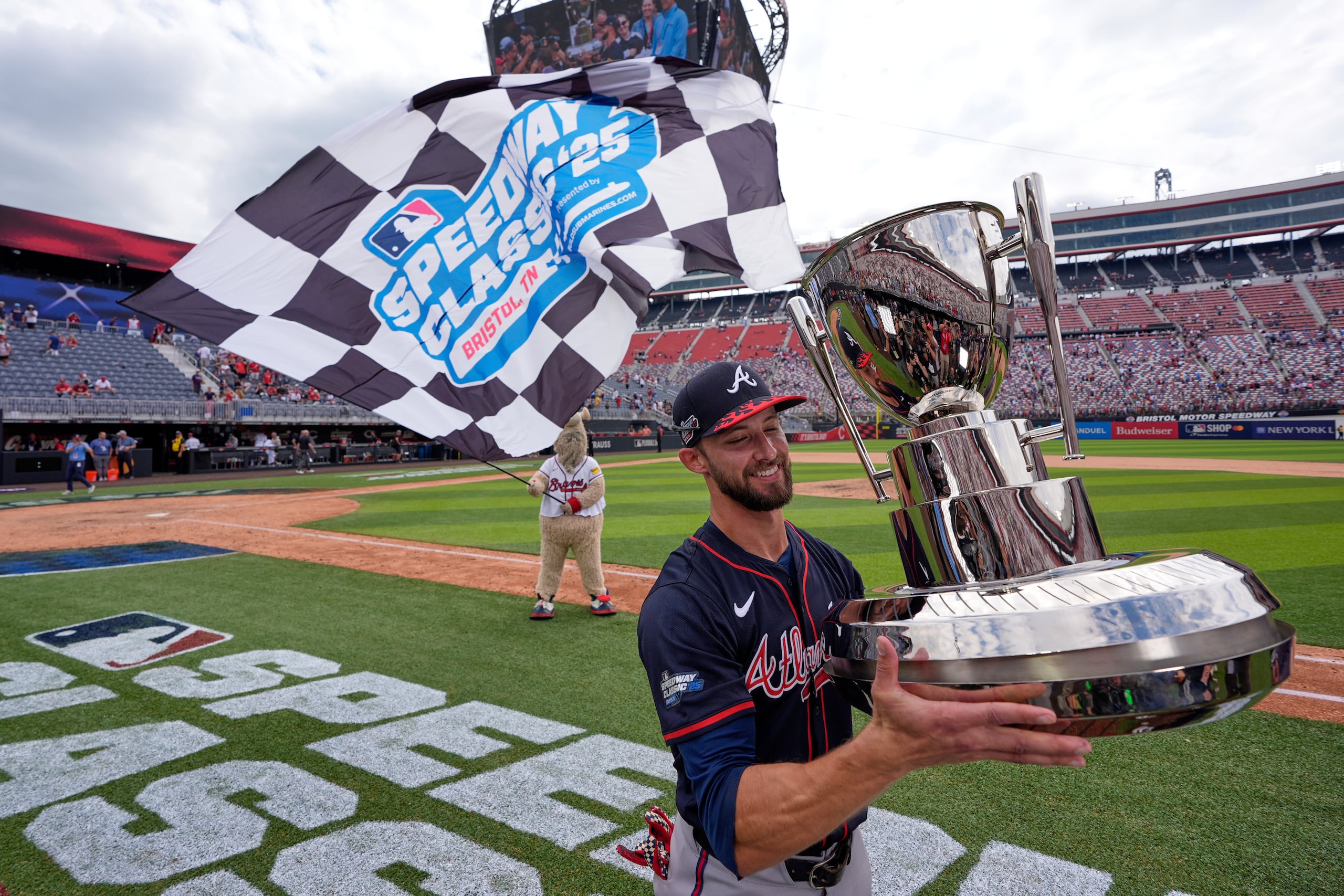 El jardinero Eli White, de los Braves de Atlanta, posa con el trofeo de ganador tras la victoria de su novena ante los Reds de Cincinnati en el Speedway Classic.