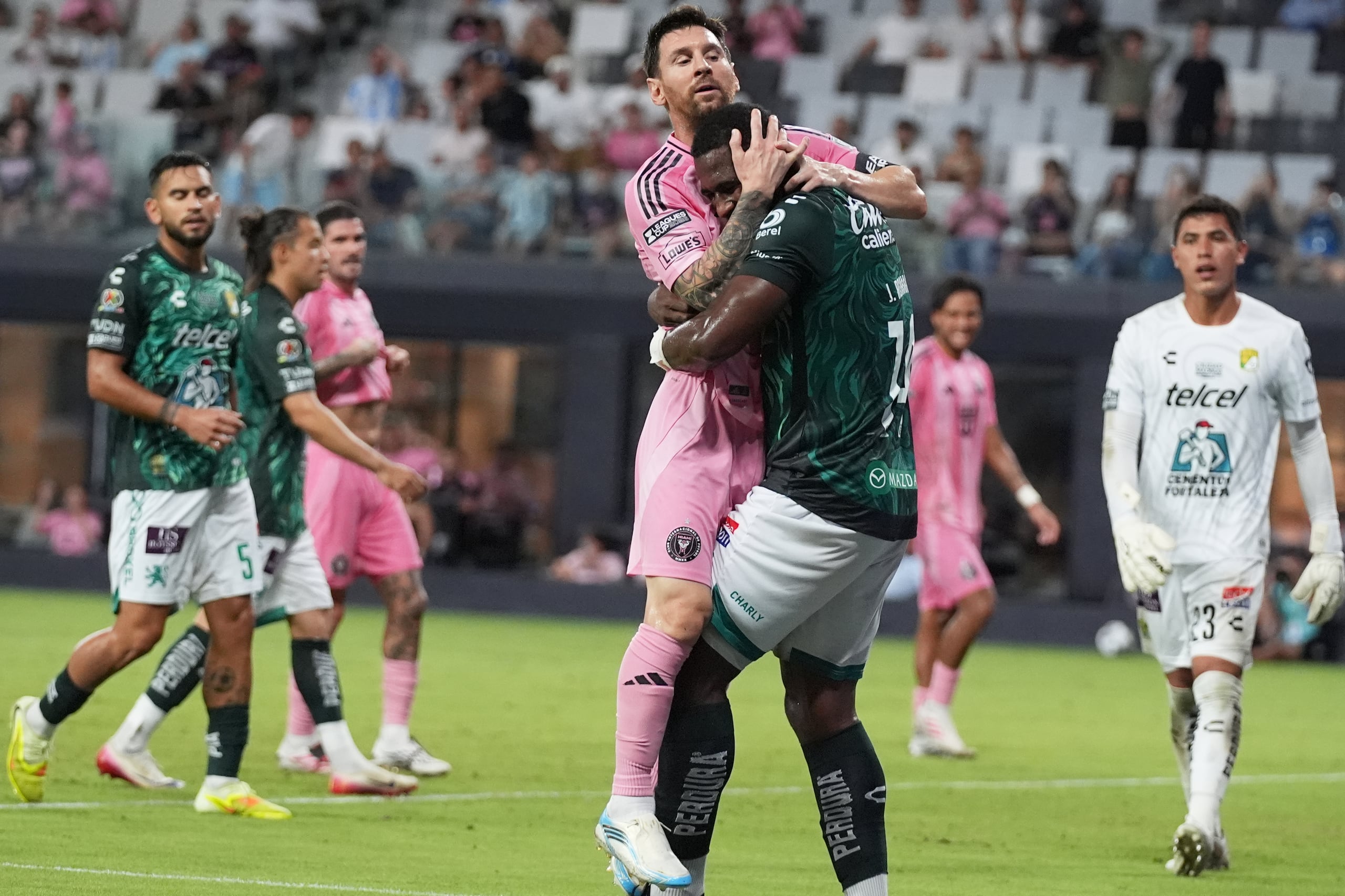 Lionel Messi, del Inter Miami, choca con Jhohan Romaña, de León, durante un encuentro de la Leagues Cup.