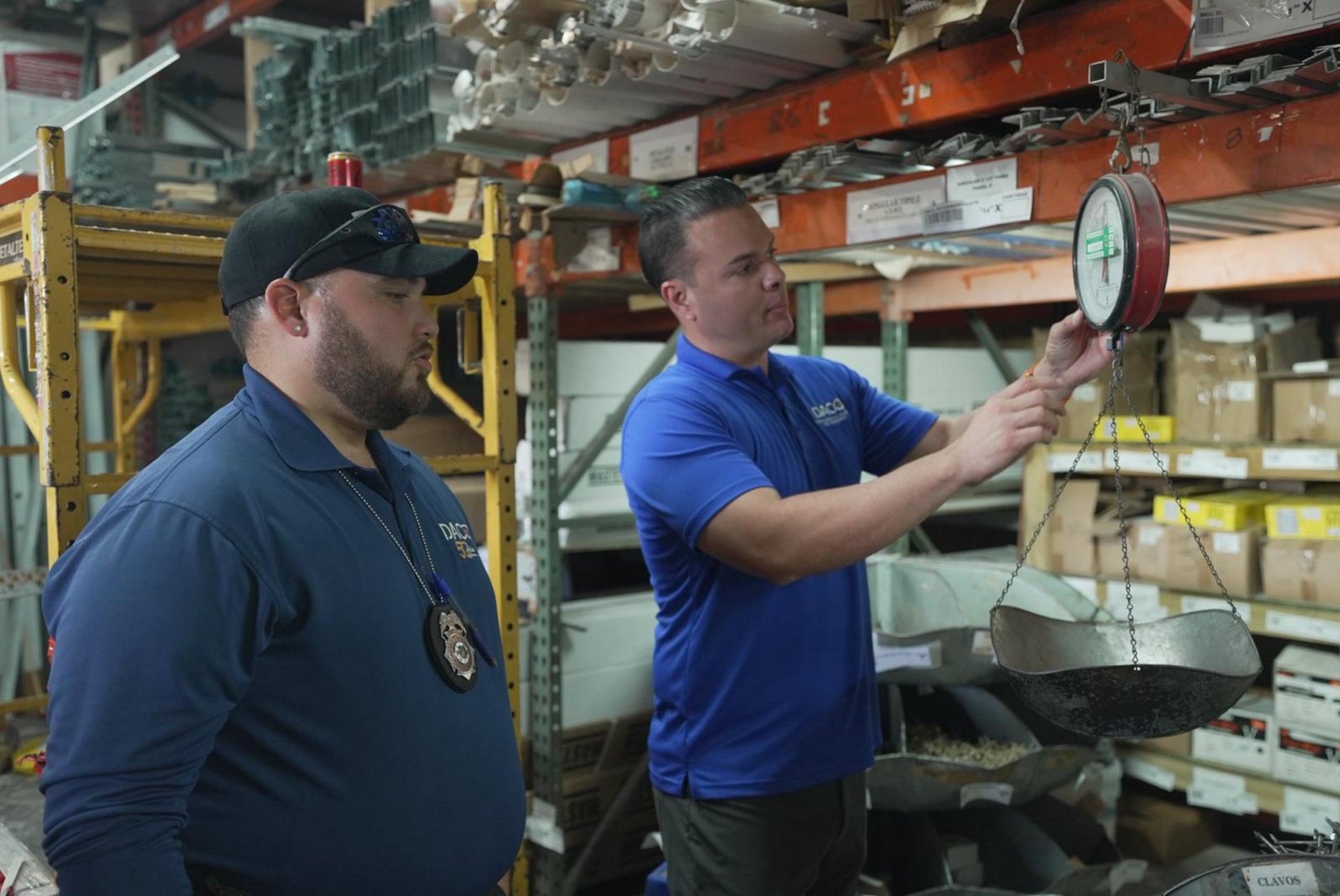 El secretario del DACO, Hiram J. Torres Montalvo, y un inspector verifican una balanza en el National Lumber & Hardware de Guaynabo.