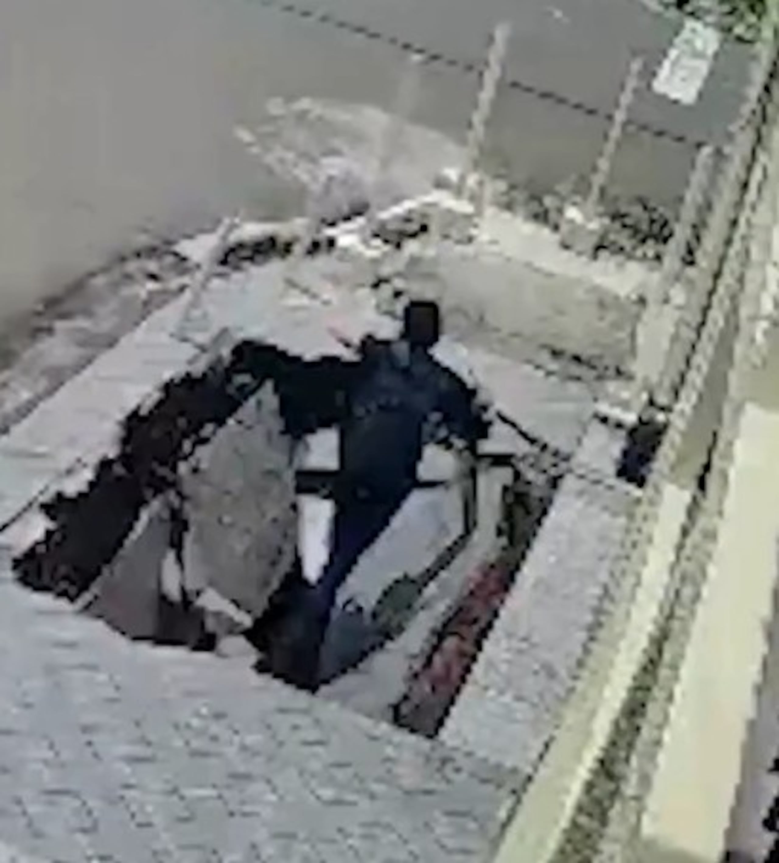 El momento en que la tierra se abre tragándose al joven, fue capturado por una cámara de seguridad.