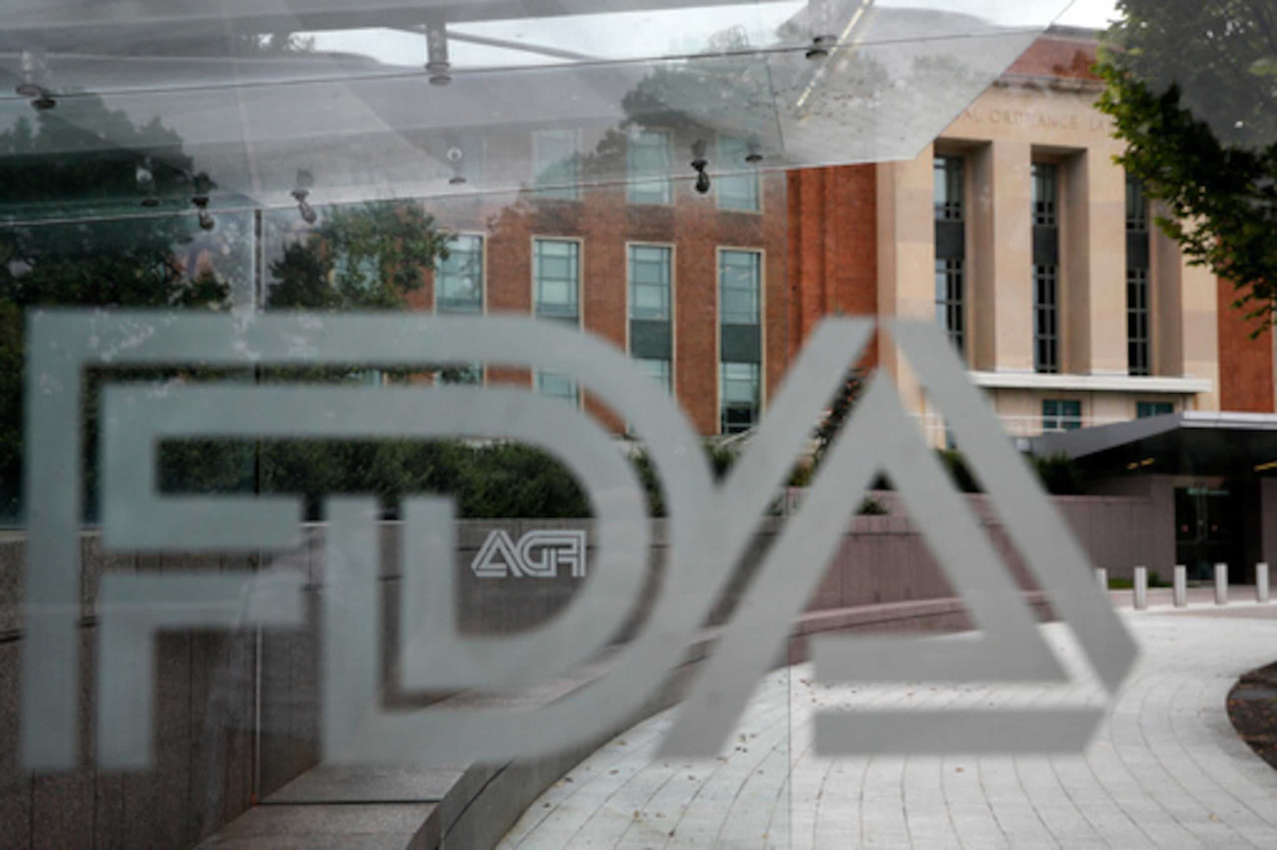 ARCHIVO - El edificio de la Administración de Alimentos y Medicamentos de Estados Unidos se ve detrás de los logotipos de la FDA en una parada de autobús en el campus de la agencia en Silver Spring, Maryland, 2 de agosto de 2018. (AP Photo/Jacquelyn Martin, Archivo)
