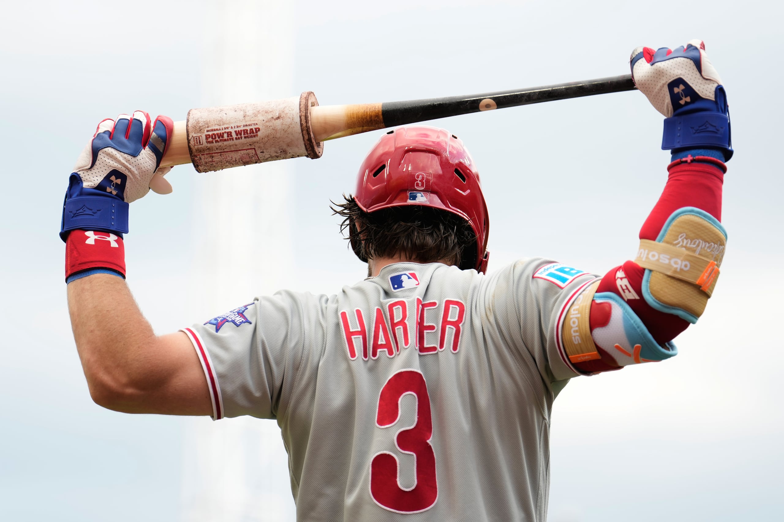 Bryce Harper, de los Phillies de Filadelfia, estira con su bate durante la primera entrada de un partido de béisbol contra los Reds de Cincinnati.