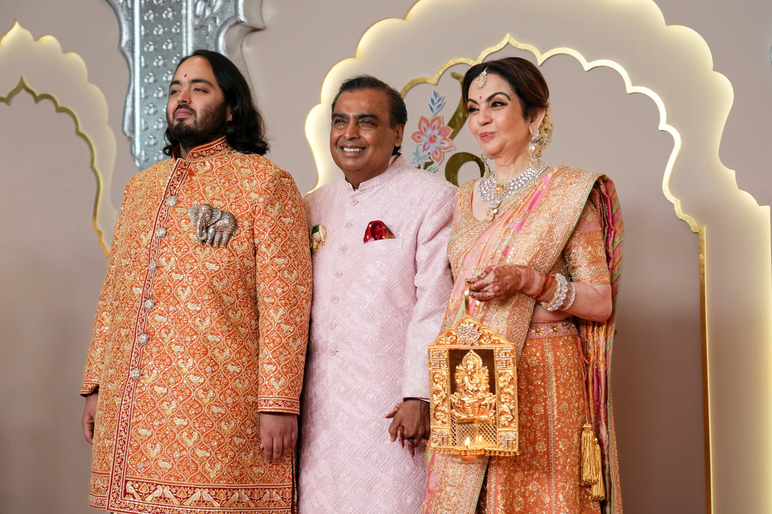 El multimillonario Mukesh Ambani, en el centro, posa junto a su hijo Anant, y esposa Nita.