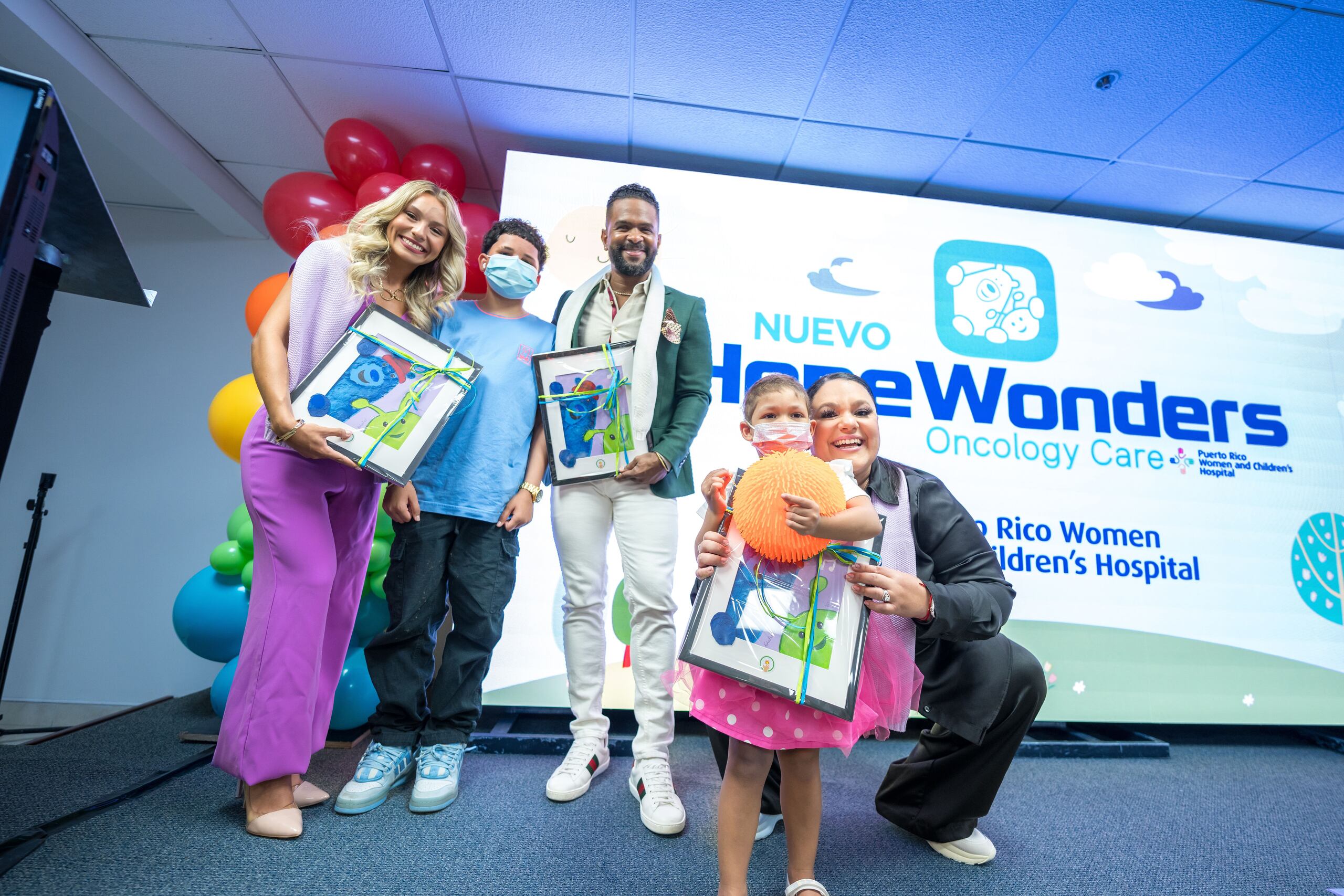 Los padrinos Jasond Calderón y Norwill Fragoso reciben un obsequio de parte de los pacientes. Los acompaña la moderadora de la actividad, Kimberly Santiago.