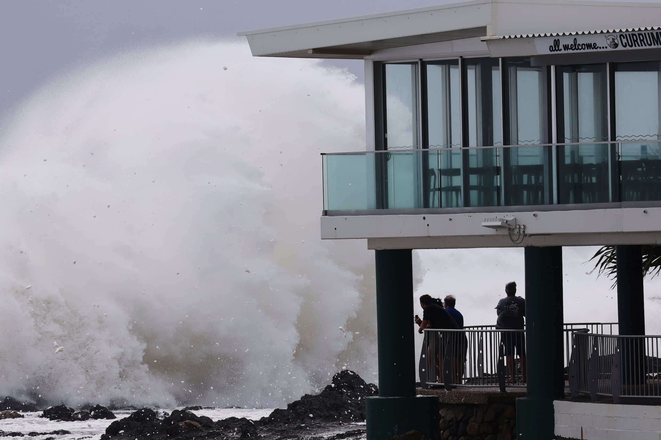 Gente mirando mientras enormes olas golpean las playas en Gold Coast, Australia, el jueves 6 de marzo de 2025.  (Jason O'Brien/AAP Image via AP)