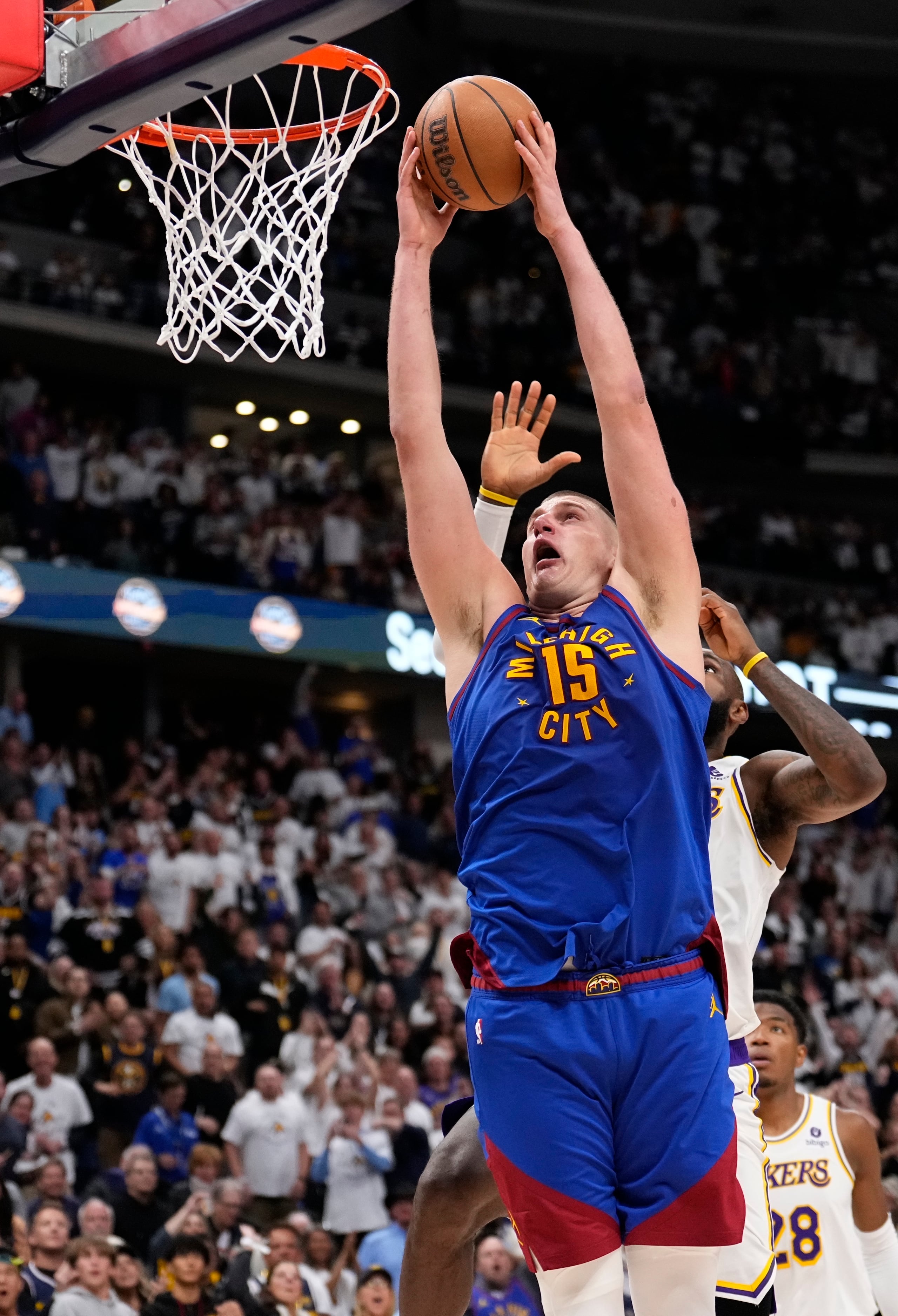 El serbio Nikola Jokic, de los Nuggets de Denver, realiza una clavada frente a LeBron James, de los Lakers de Los Ángeles, el sábado 20 de abril de 2024 (AP Foto/Jack Dempsey)