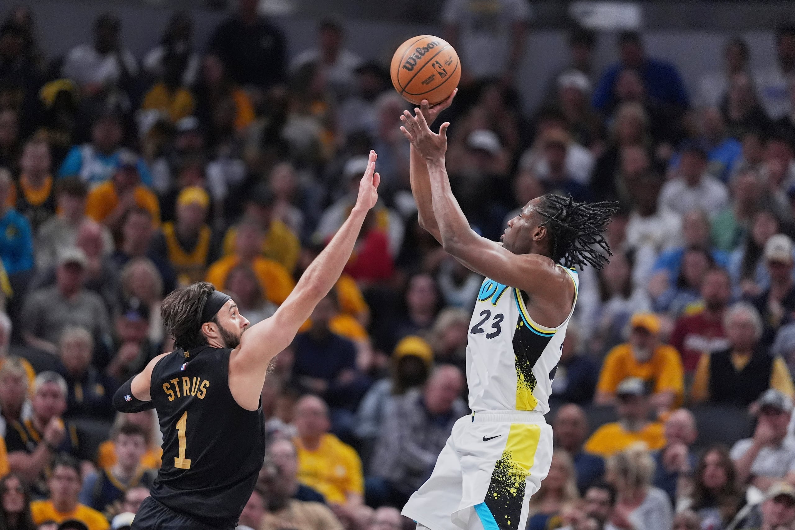 Aaron Nesmith (23), de los Pacers de Indiana, dispara a la canasta ante la marca defensiva de Max Strus (1), de los Cavaliers de Cleveland, en la primera mitad del cuarto juego de la serie de playoffs de la NBA en la Conferencia Este, el domingo 11 de mayo de 2025, en Indianápolis. (AP Foto/Michael Conroy)