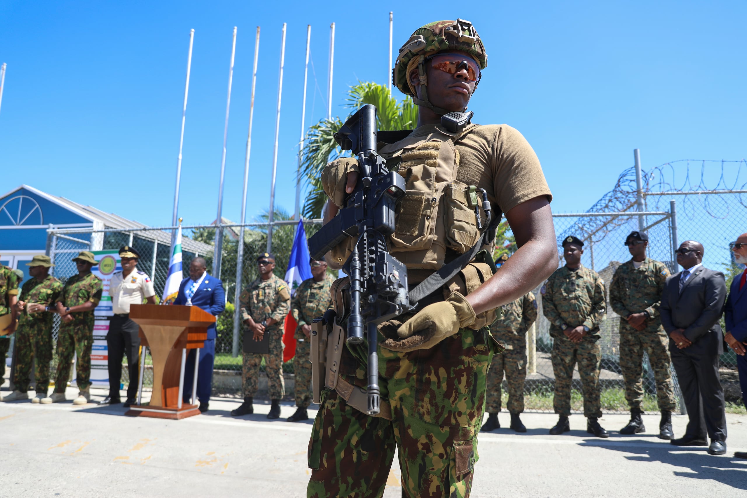 Un policía keniano, que forma parte de una fuerza multinacional respaldada por la ONU, monta guardia en la pista durante una ceremonia para recibir a los policías de las Bahamas en el Aeropuerto Internacional Toussaint Louverture en Puerto Príncipe, Haití, el viernes 18 de octubre de 2024. (AP Foto/Odelyn Joseph)