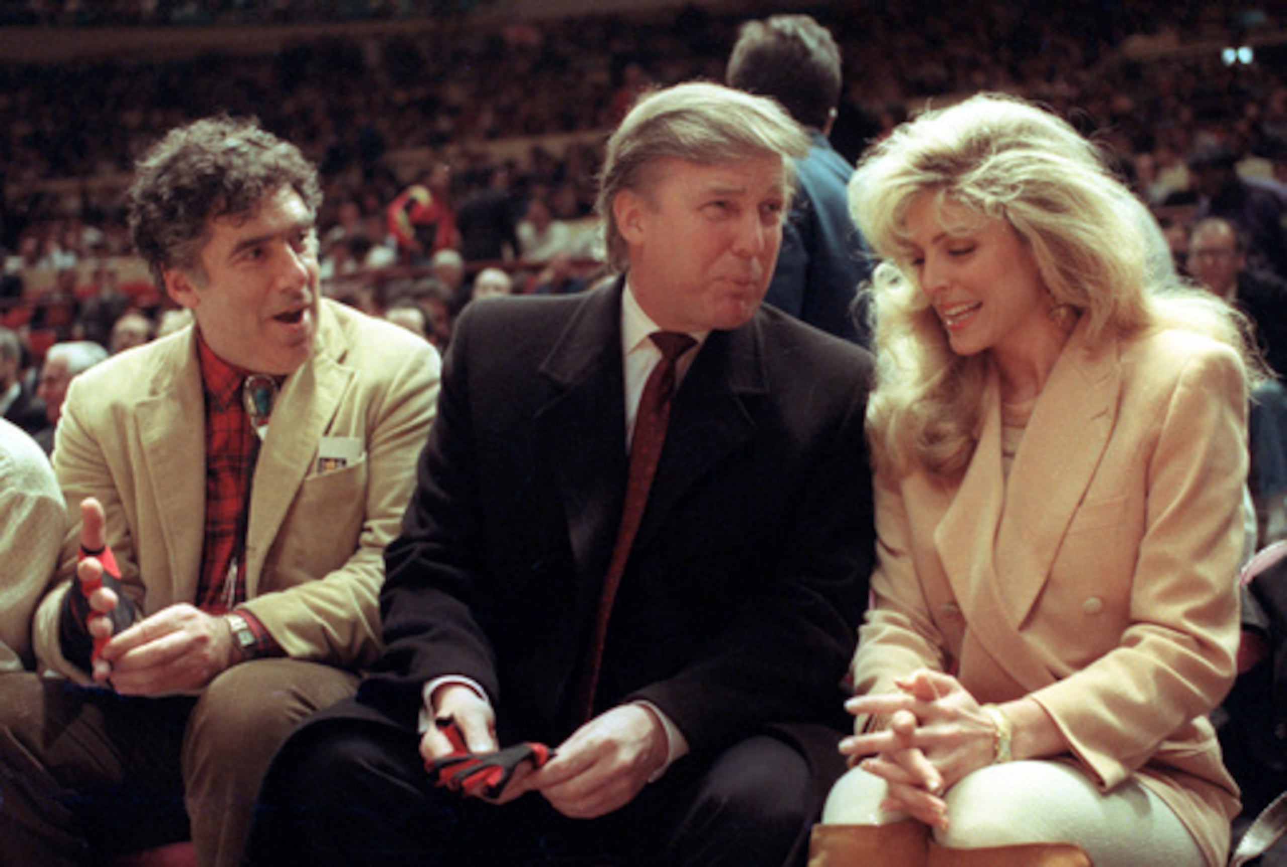 ARCHIVO - El actor Elliott Gould, Donald Trump y Marla Maples durante un partido de la NBA entre los Phoenix Suns y los New York Knicks en el Madison Square Garden, en 1991.