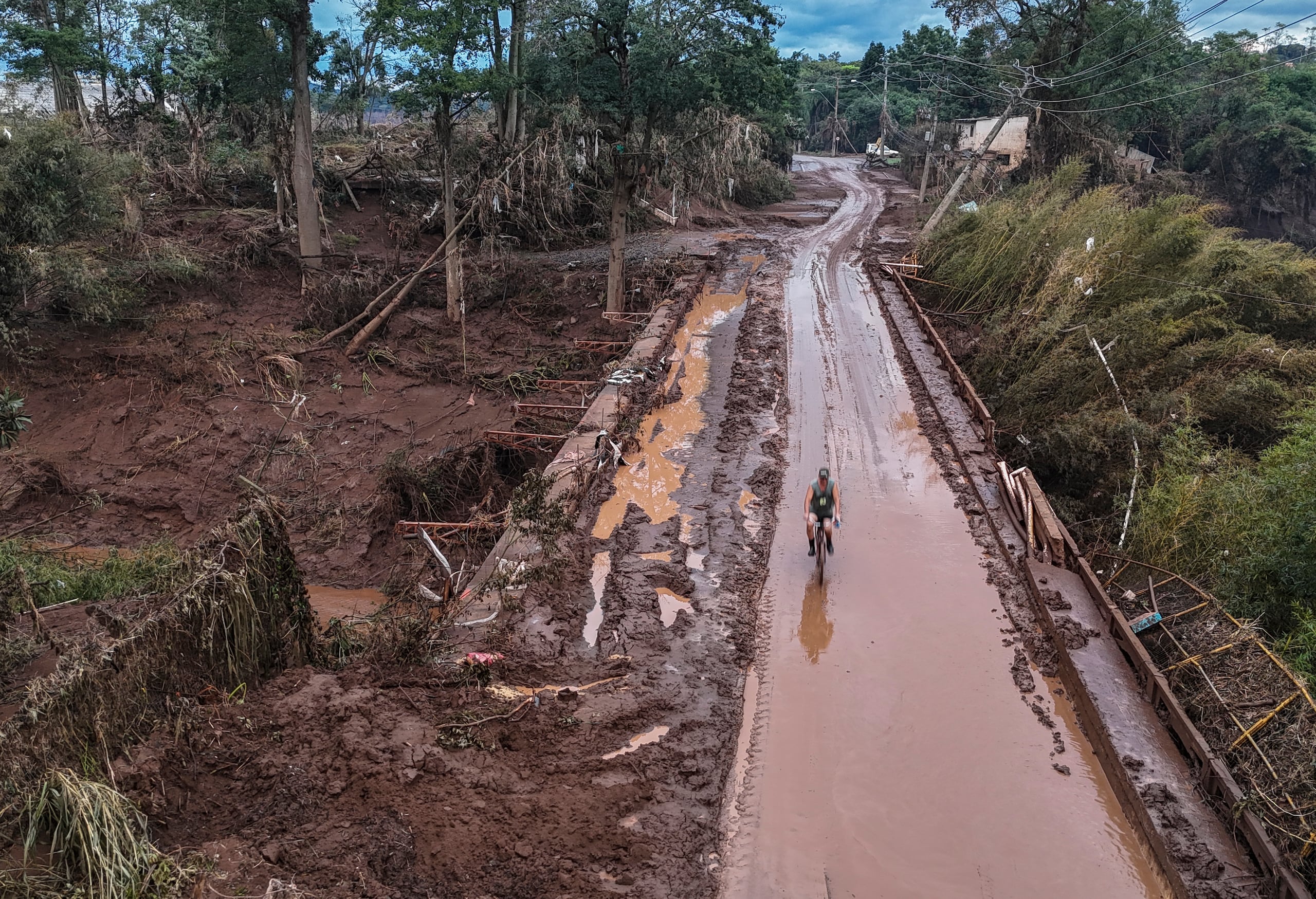 Fotografía tomada con un dron que muestra un ciclista pasando por el puente tras inundación causada por el desbordamiento del río Taquari, en la ciudad de Lajeado en el estado de Rio Grande do Sul en el sur de Brasil. (EFE/Sebastião Moreira)