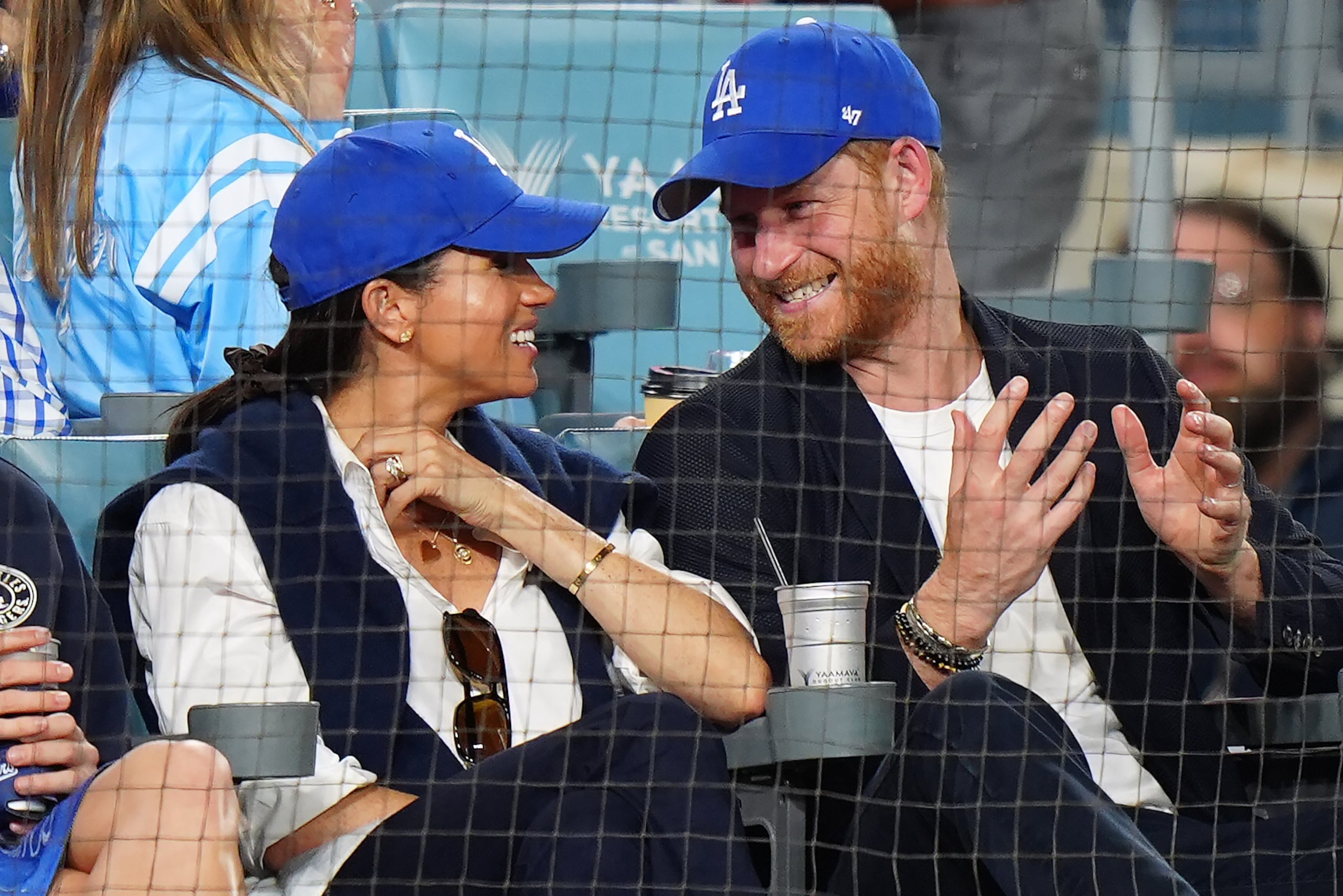 El príncipe Enrique y su esposa Meghan Markle ríen durante el cuarto juego de la Serie Mundial, entre los Dodgers de Los Ángeles y los Azulejos de Toronto, el martes 28 de octubre de 2025 (Frank Gunn/The Canadian Press via AP)