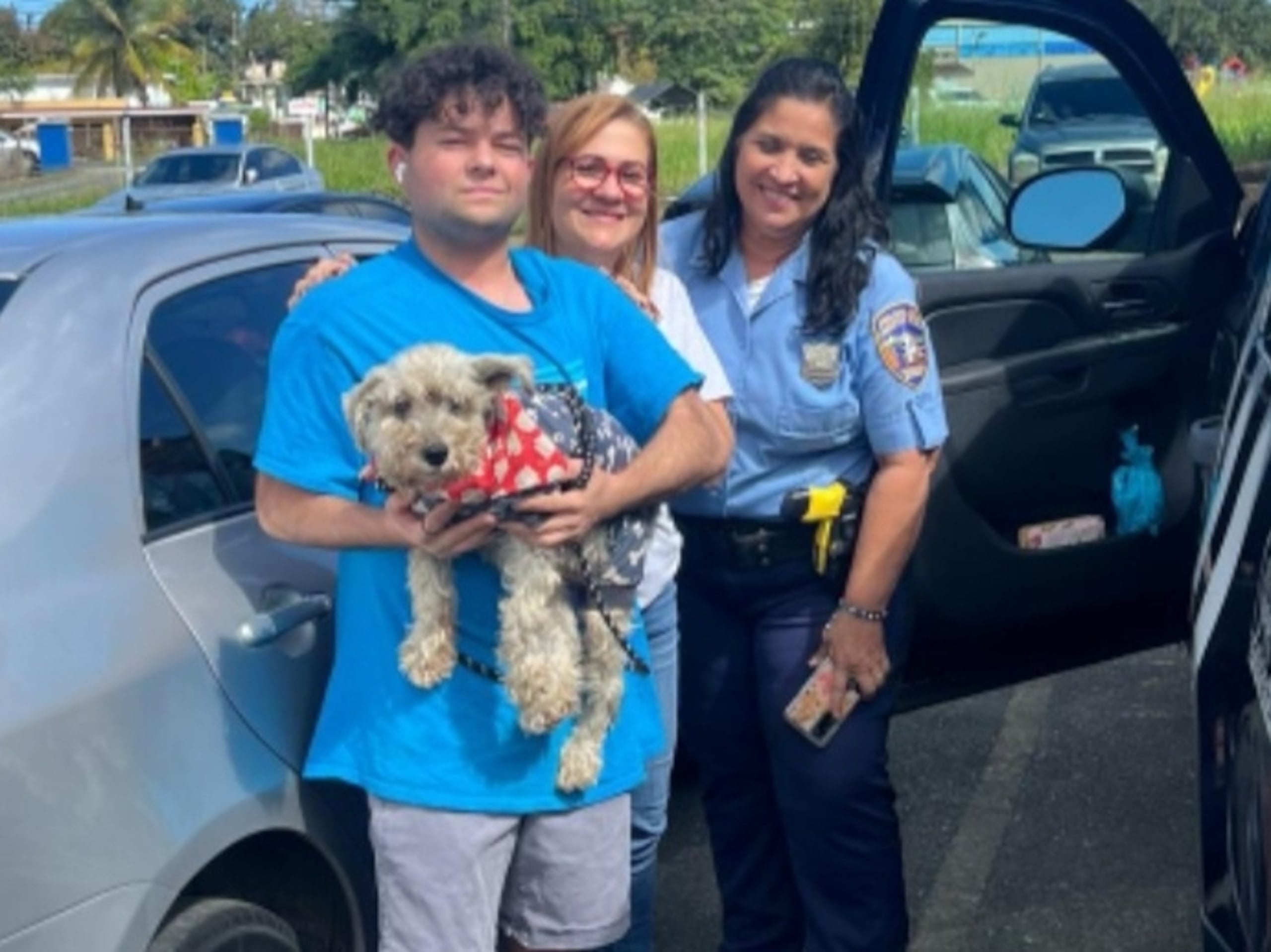 La agente Wanda E. Rivera García con los dueños del perrito.