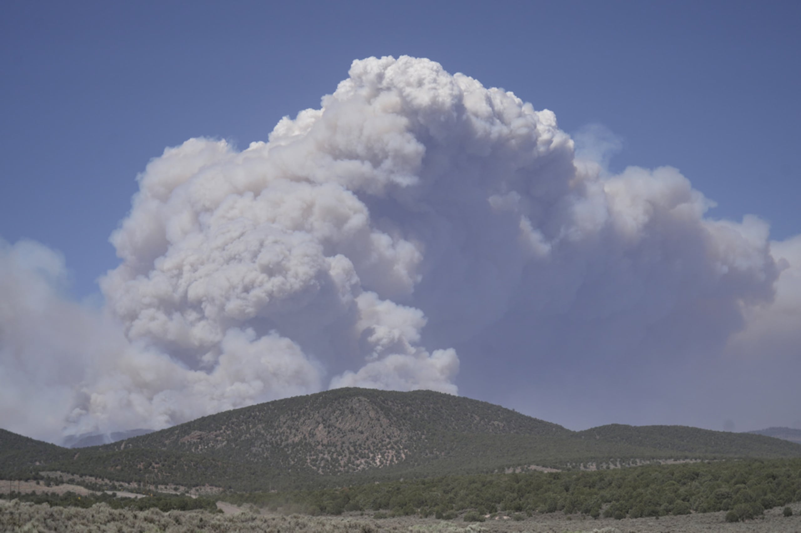 Una columna de humo se eleva del incendio Cottonwood el 26 de junio de 2026, cerca de Beaver, Utah.