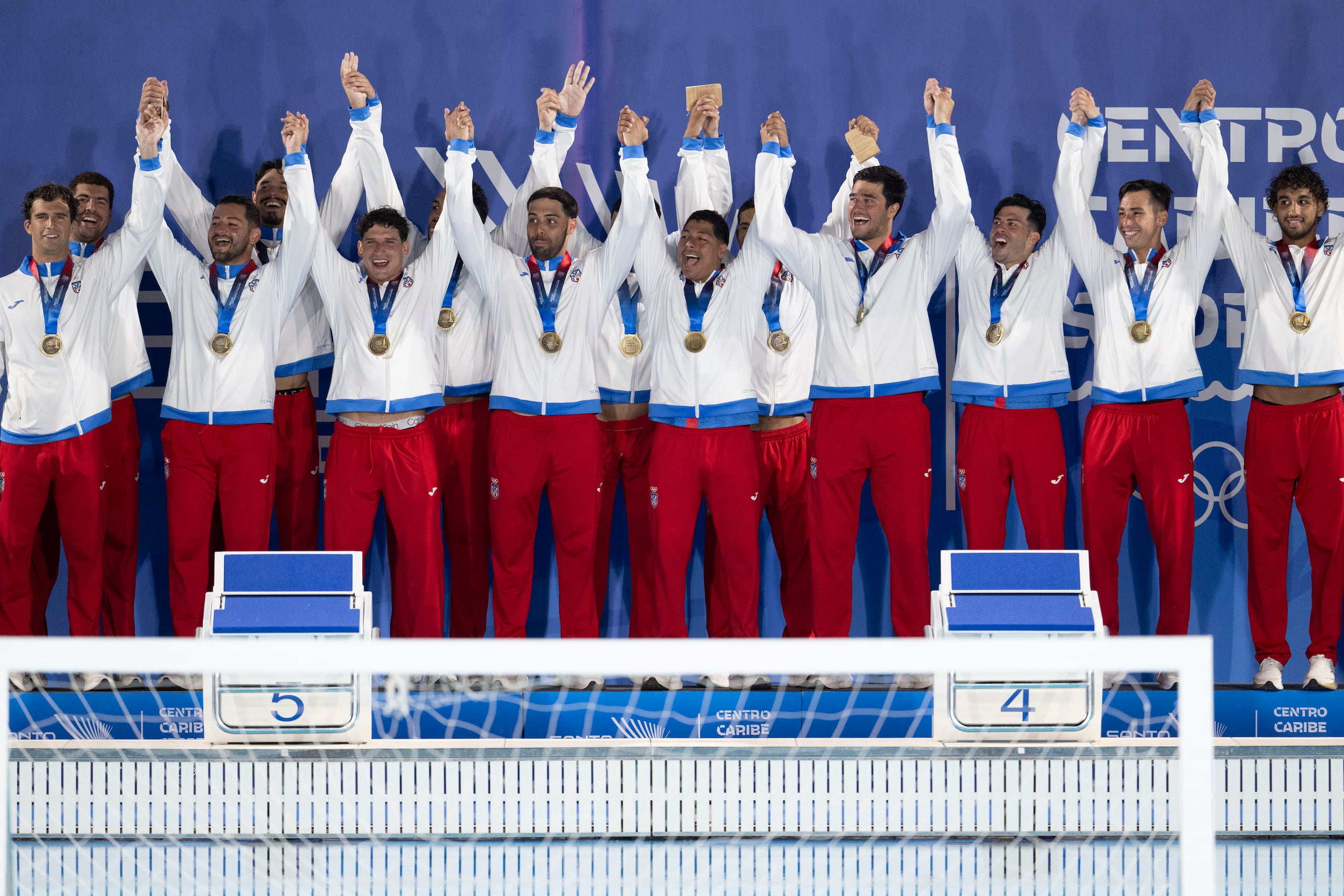 El Equipo Nacional de polo acuático masculino celebra tras recibir la medalla de oro en los Juegos Centroamericanos y del Caribe.