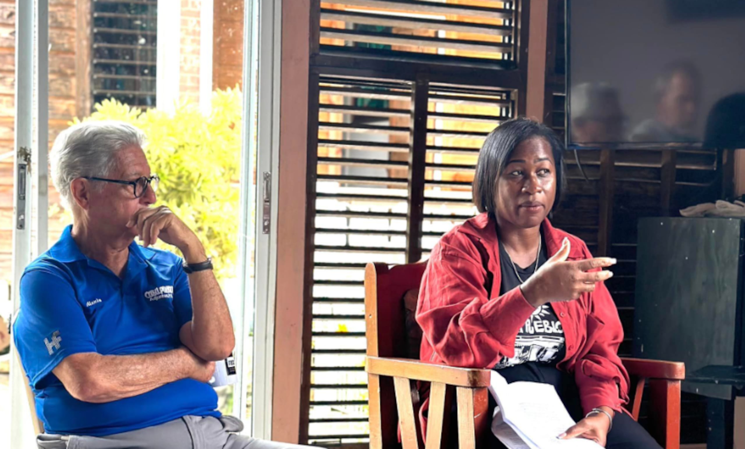 Arturo Massol, fundado de Casa Pueblo, escucha la líder de la Red Común Nacional Organizada de Ciudadanos/as Dominicanos/as (Reconoci.do), Epifania St Chals, quien visitó a Adjuntas.