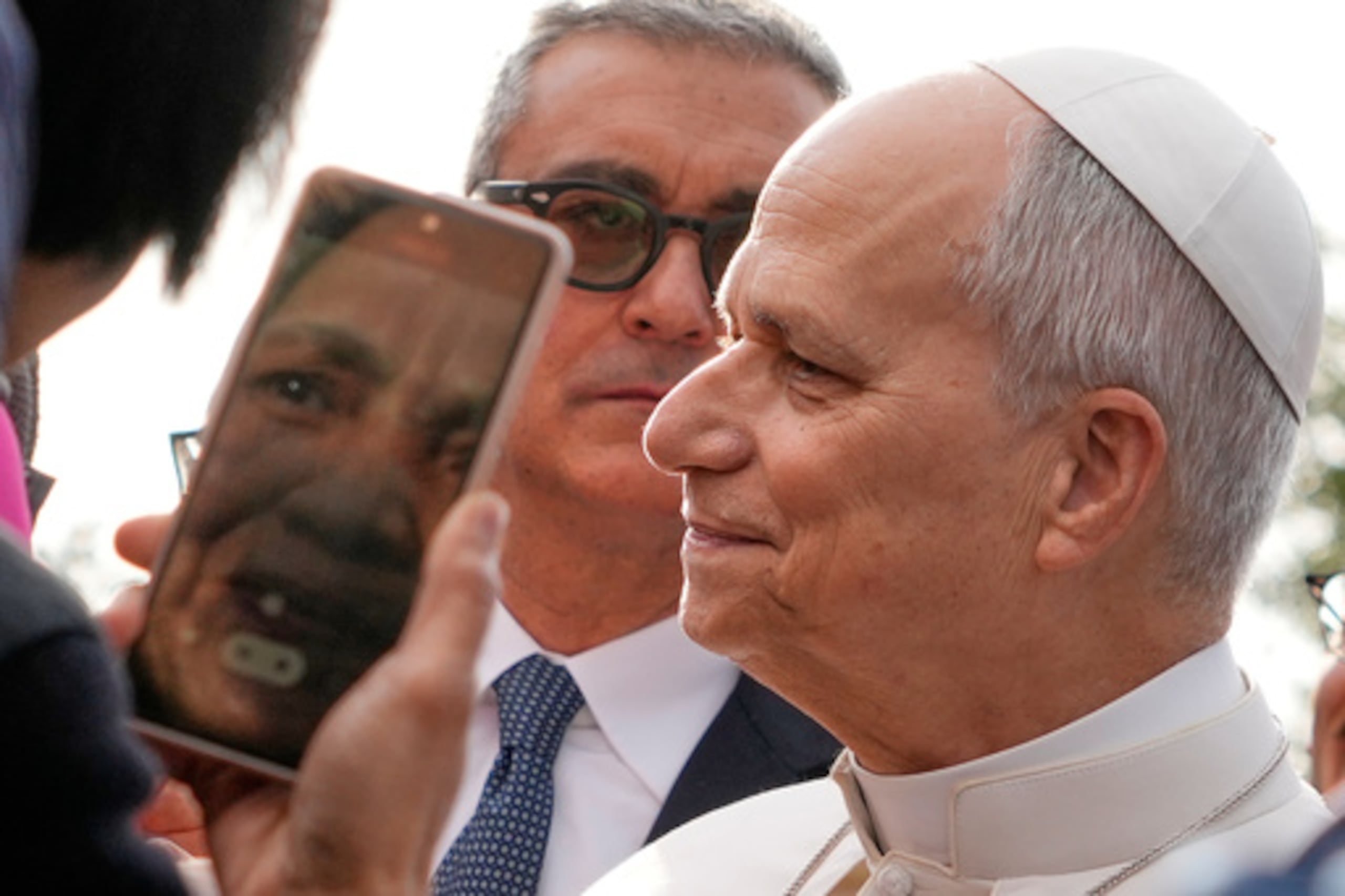 El jefe de la Seguridad Vaticana, Gianluca Gauzzi Broccoletti, en el centro, sigue al Papa León XIV mientras visita el complejo parroquial de Santa Maria della Presentazione en las afueras de Roma, domingo 8 de marzo de 2026. (AP Photo/Gregorio Borgia)