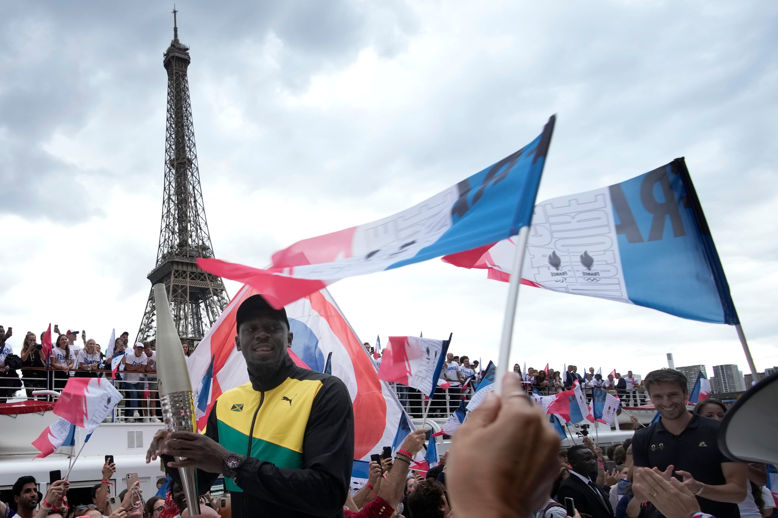 Tony Estanguet (derecha) - presidente del Comité Organizador de los Juegos Olímpicos de París 2024, y el exatleta jamaiquino Usain Bolt asisten a la ceremonia de la antorcha olímpica en París.