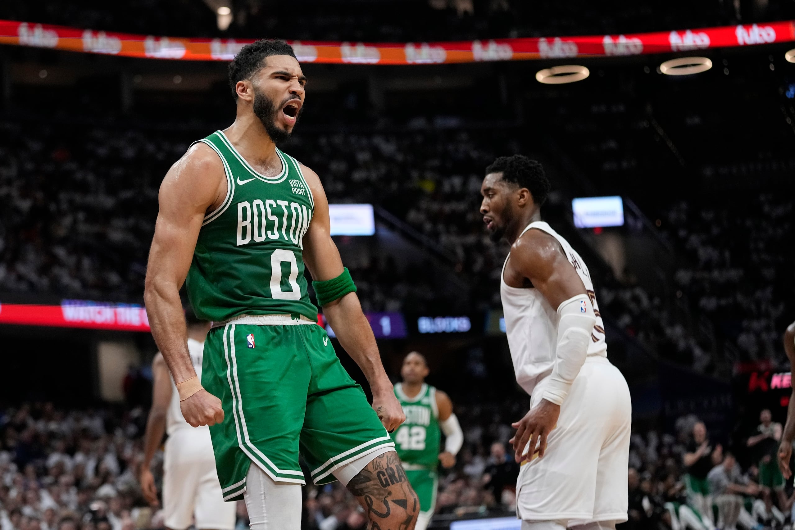 Jayson Tatum, alero de los Celtics de Boston, festeja frente a Donovan Mitchell, de los Cavaliers de Cleveland, durante el partido de playoffs realizado el sábado 11 de mayo de 2024 (AP Foto/Sue Ogrocki)