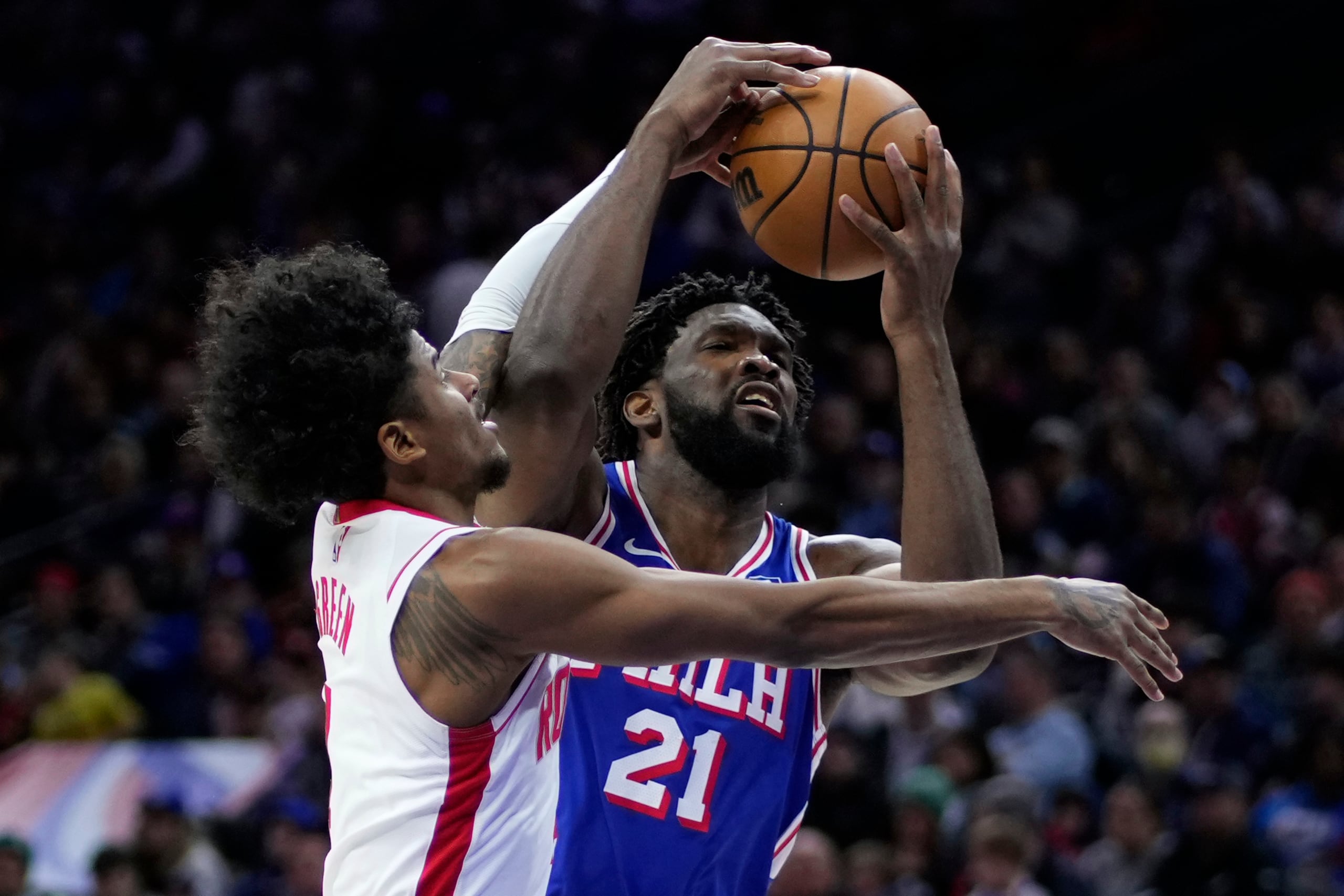 Joel Embiid (derecha) de los 76ers de Filadelfia intenta anotar ante Jalen Green de los Rockets de Houston.