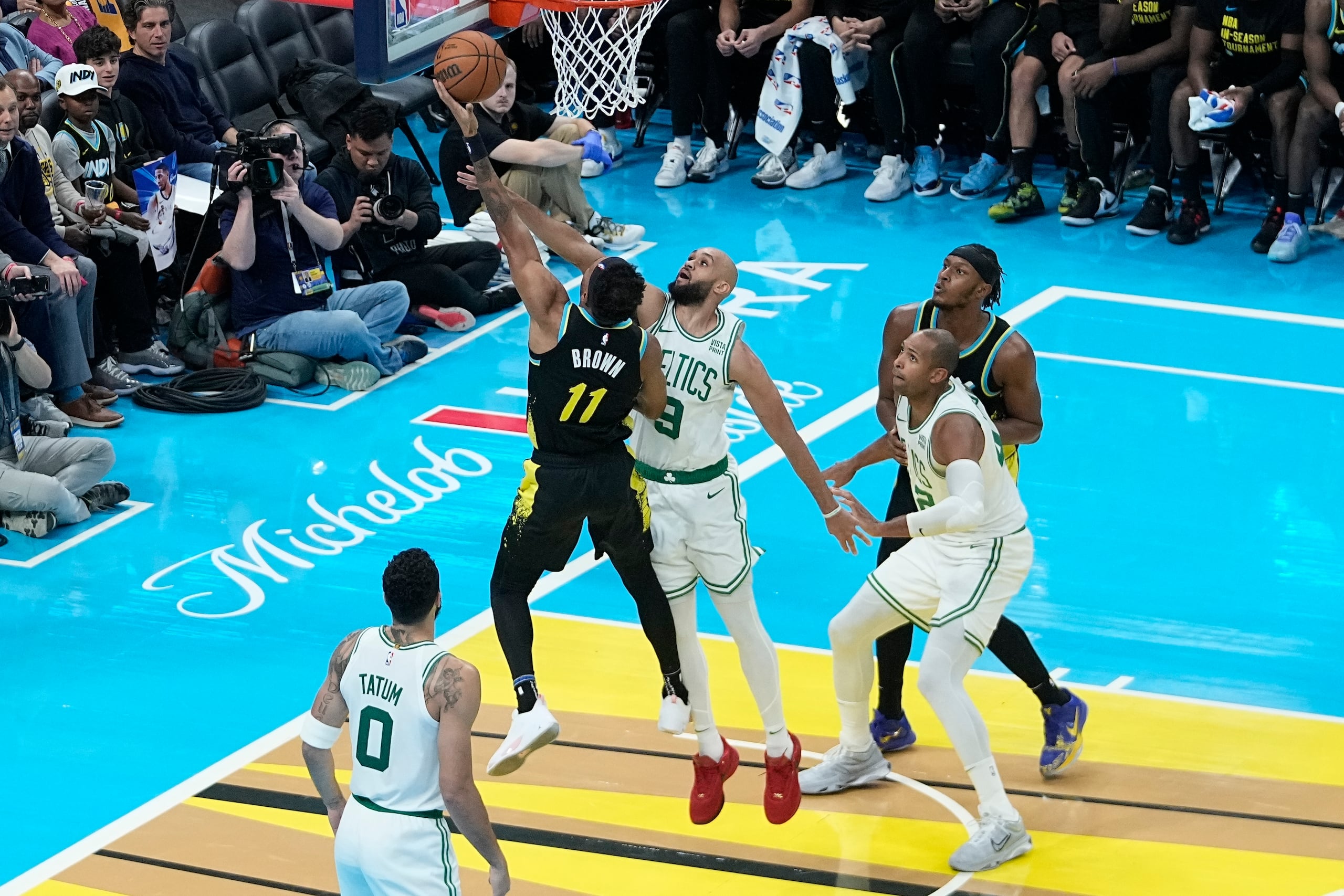Bruce Brown (11), de los Pacers de Indiana, dispara ante el intento de bloqueo de Derrick White (9), de los Celtics de Boston, durante la segunda mitad del juego del torneo In-Season, el lunes 4 de diciembre de 2023, en Indianápolis. (AP Foto/Darron Cummings)