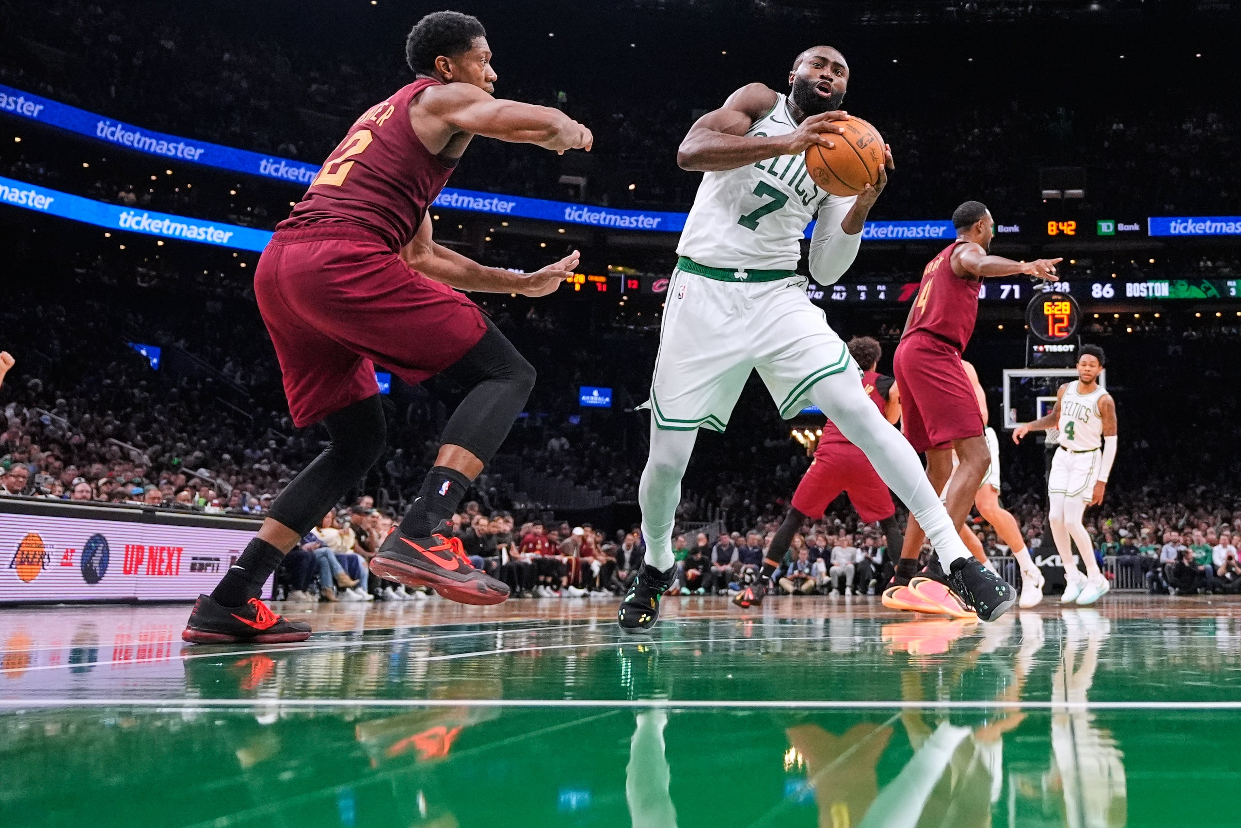 Jaylen Brown (7), de los Celtics de Boston, lleva el balón hacia la canasta, mientras De'Andre Hunter (12), de los Cavaliers de Cleveland, defiende durante la segunda mitad del juego de baloncesto de la NBA, el miércoles 29 de octubre de 2025, en Boston. (AP Foto/Charles Krupa)