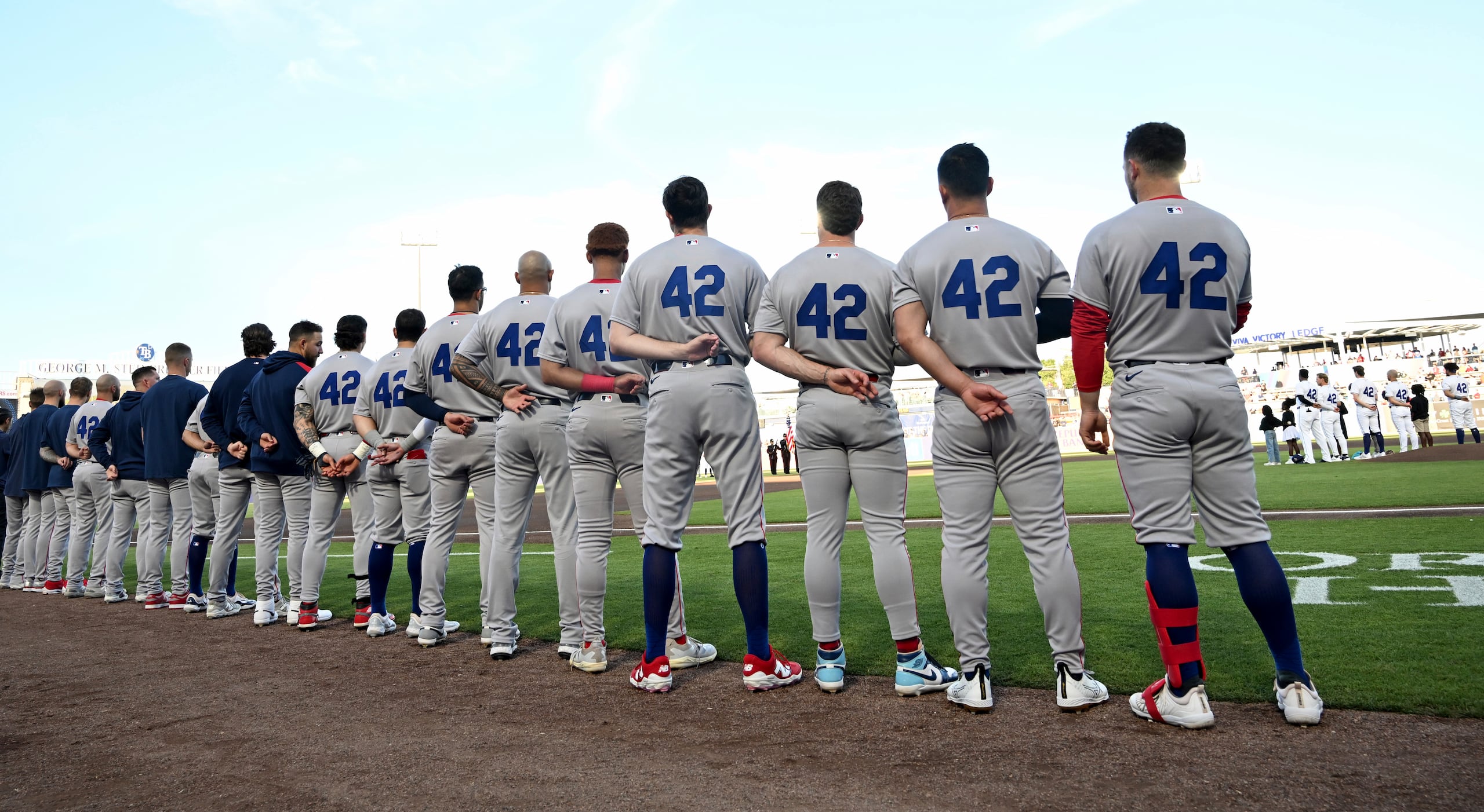 Jugadores de los Medias Rojas de Boston alineado para el himno nacional antes del juego ante los Rays de Tampa Bay portando una camiseta con el número 42 por el Día de Jackie Robinson el martes 15 de abril del 2025. (AP Foto/Jason Behnken)