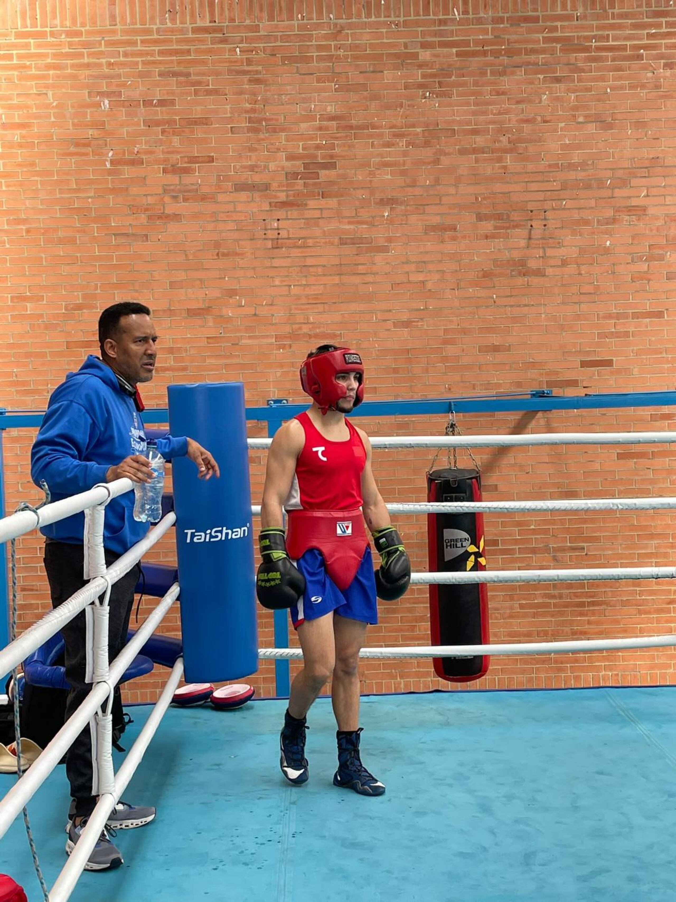 La púgil Gracemarie Quiles y su entrenador Carlos Espada se preparan para un salto de guanteo en la base de Colombia.