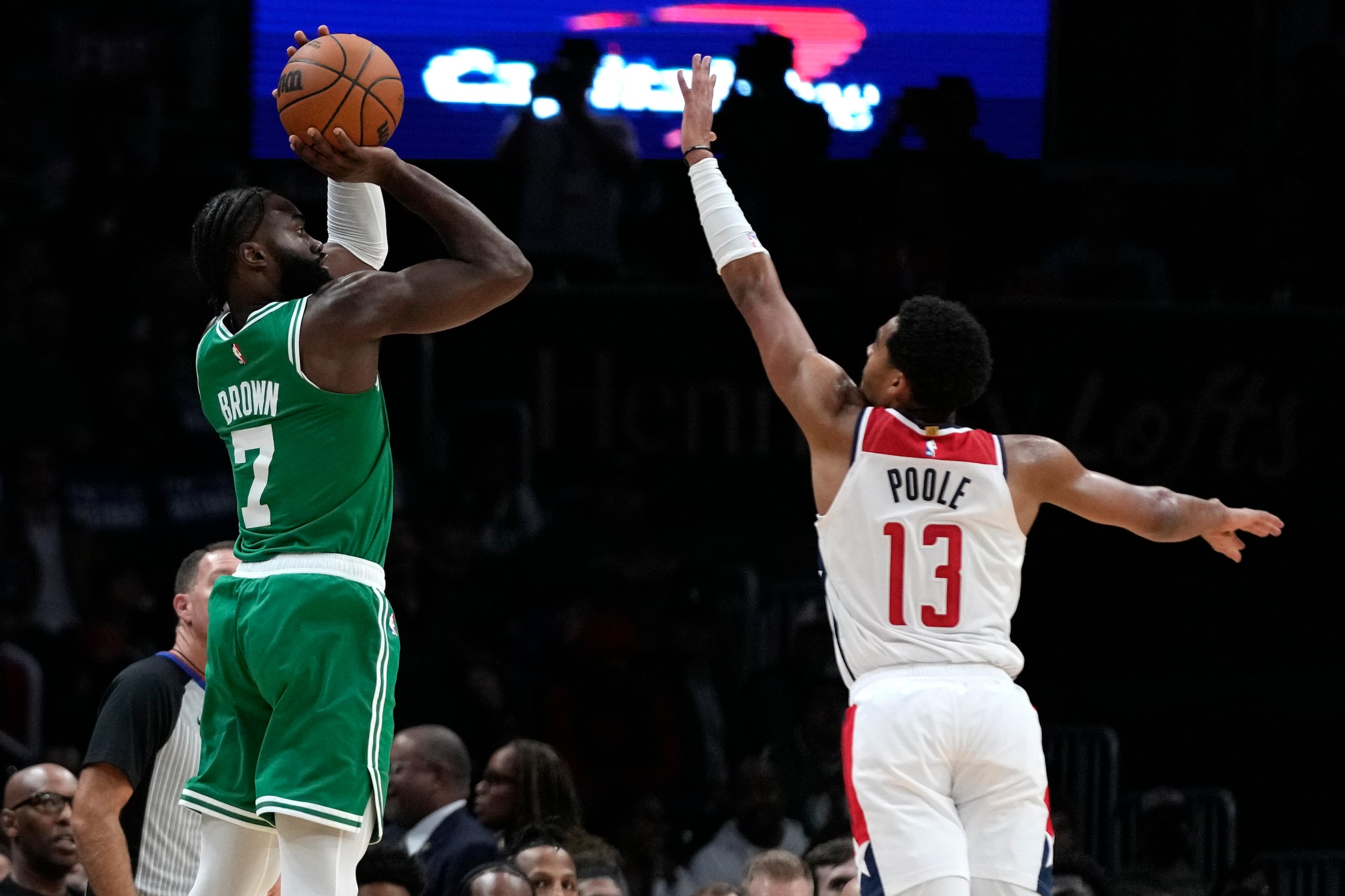 El base de los Boston Celtics, Jaylen Brown (7), dispara sobre el base de los Washington Wizards, Jordan Poole (13), durante la primera mitad de un partido de baloncesto de la NBA el lunes 30 de octubre de 2023 en Washington. (Foto AP/Mark Schiefelbein)