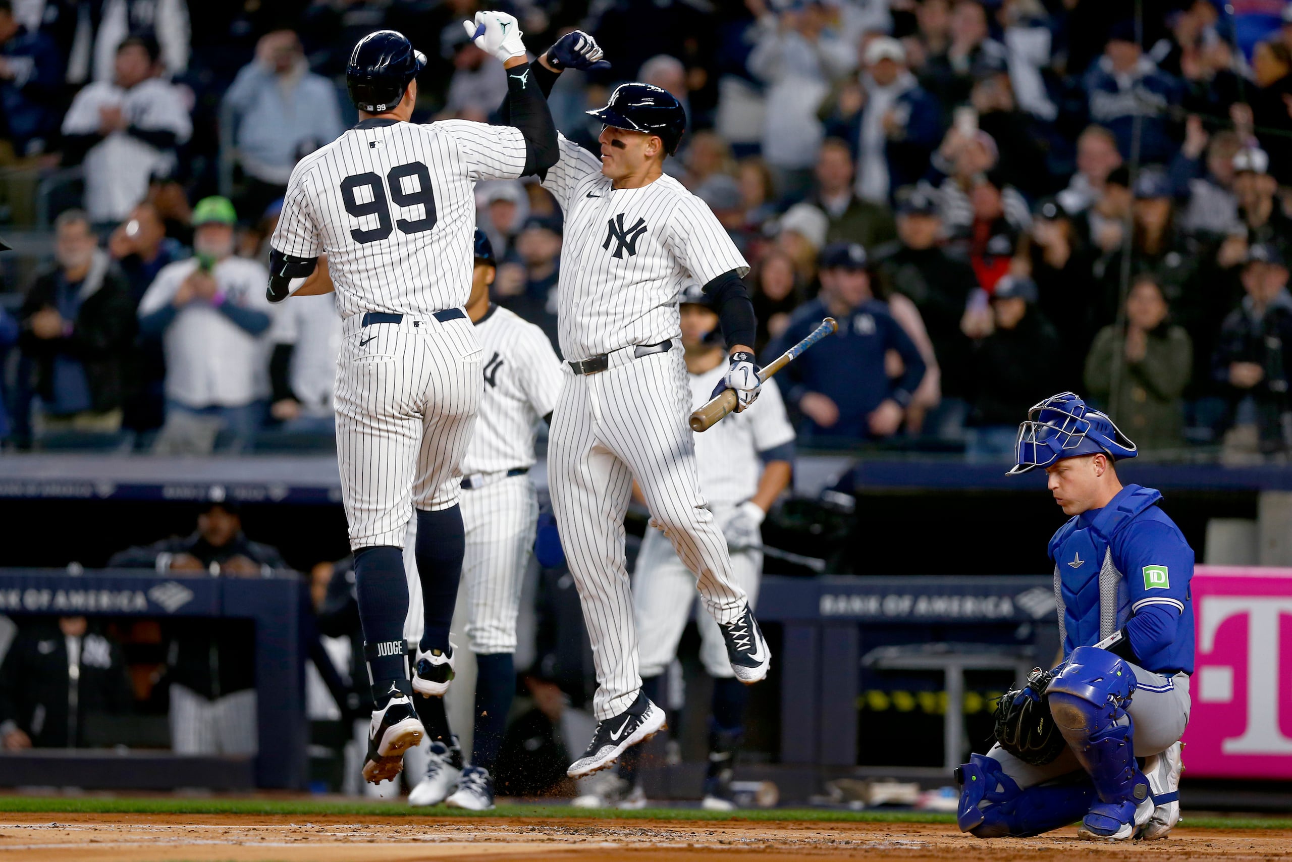 Aaron Judge, de los Yankees de Nueva York (izquierda) es felicitado por su compañero de equipo Anthony Rizzo luego de su cuadrangular de dos carreras, cerca del receptor de los Azulejos de Toronto Brian Serven durante la primera entrada del juego de béisbol el sábado 6 de abril de 2024, en Nueva York. (AP Foto/John Munson)