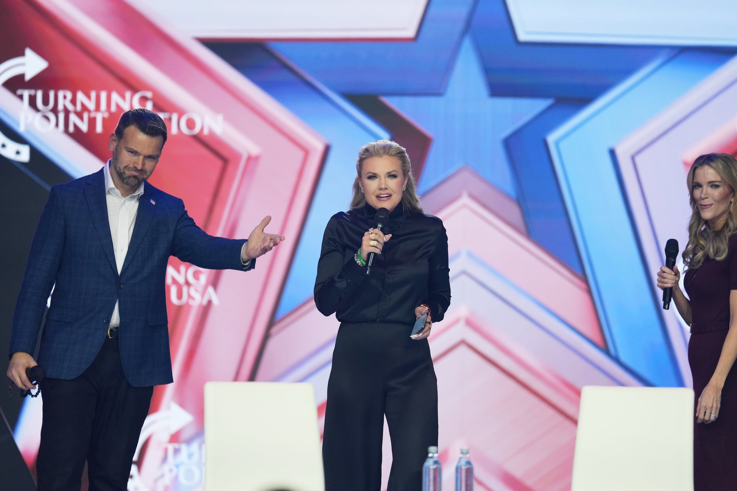 Erika Kirk, en el centro, habla mientras Jack Posobiec, a la izquierda, y Megyn Kelly miran durante la conferencia AmericaFest 2025 de Turning Point USA, el viernes 19 de diciembre de 2025, en Phoenix.