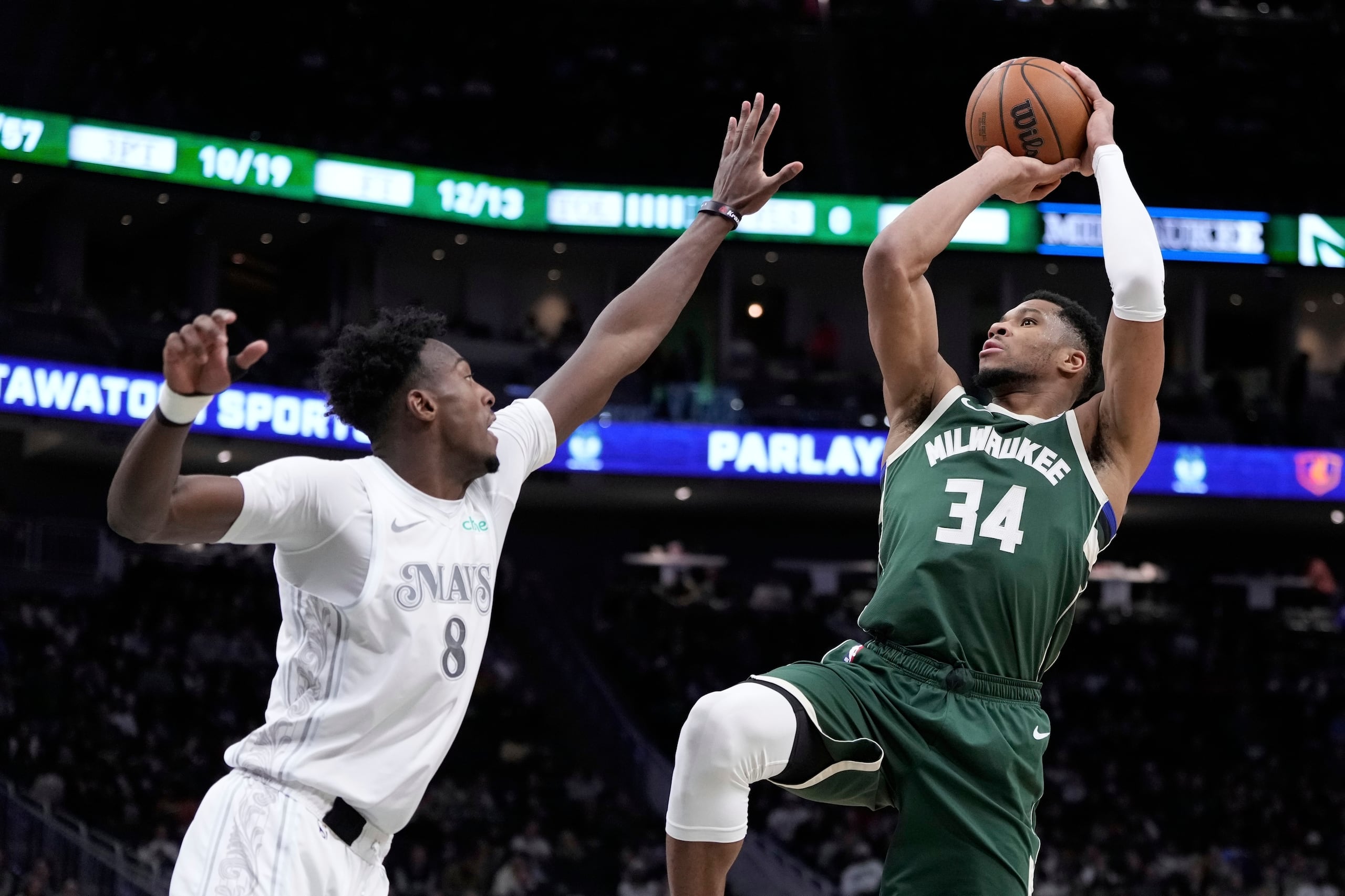 Giannis Antetokounmpo, de los Bucks de Milwaukee, dispara sobre Olivier-Maxence Prosper, de los Mavericks de Dallas, durante la segunda mitad del juego de baloncesto de la NBA.