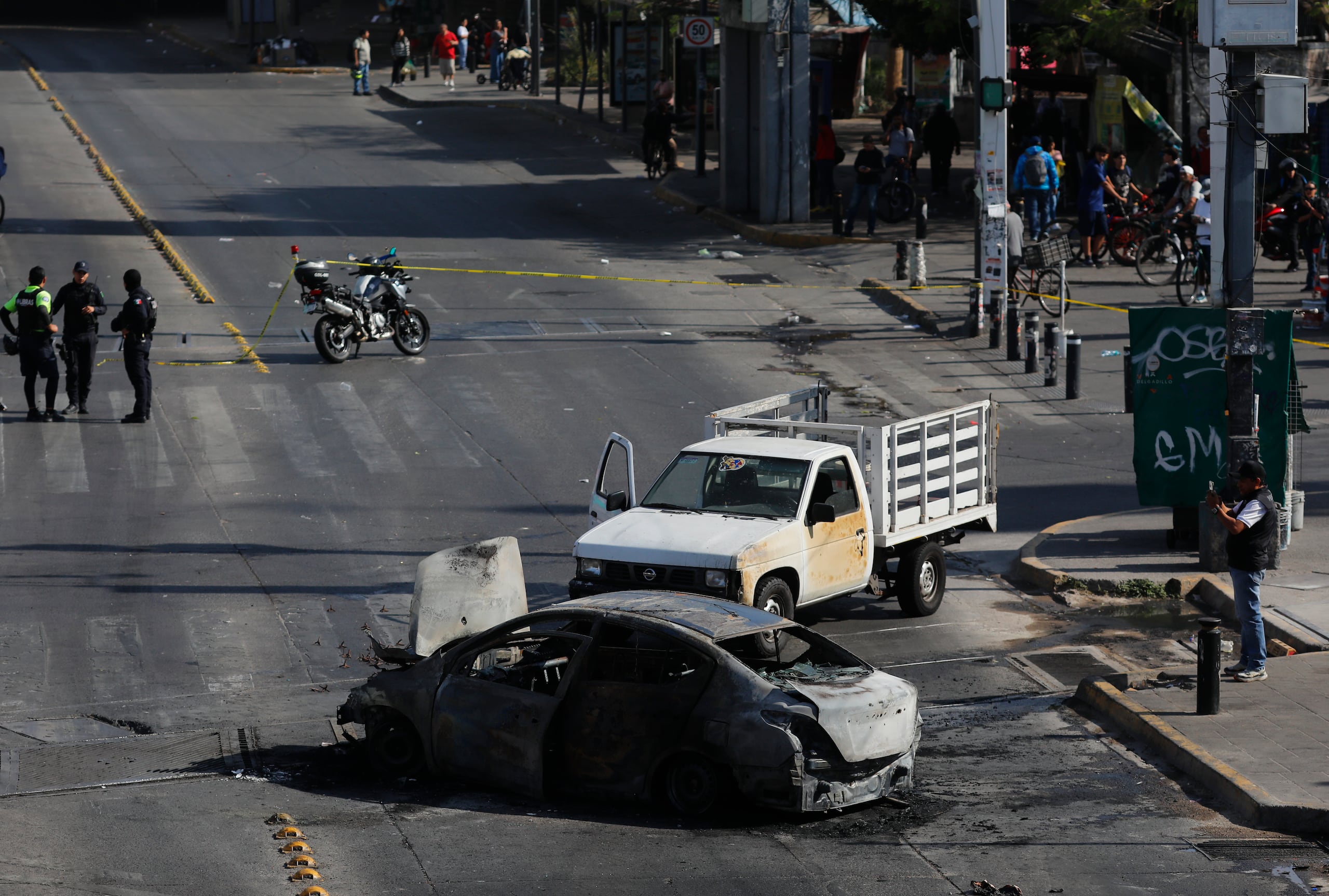 Fotografía que muestra un bloqueo con vehículos incendiados este domingo, en una vía de Guadalajara (México). EFE/ Francisco Guasco