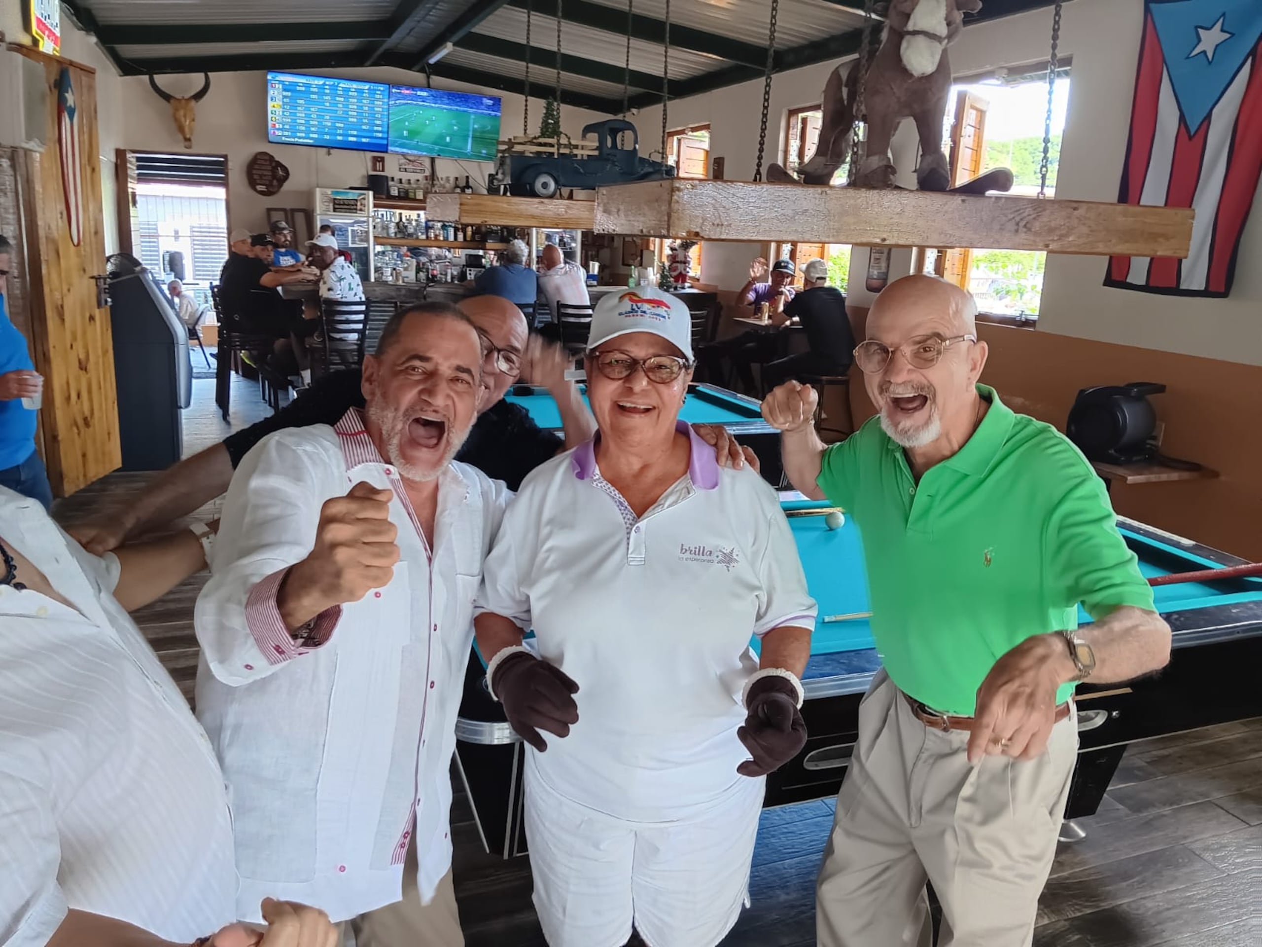 Un grupo de hípicos celebran junto a Vilma Machado en el marco del 50 aniversario del día que esta se convirtió en la primera jockette en montar en una carrera en el hipismo boricua.